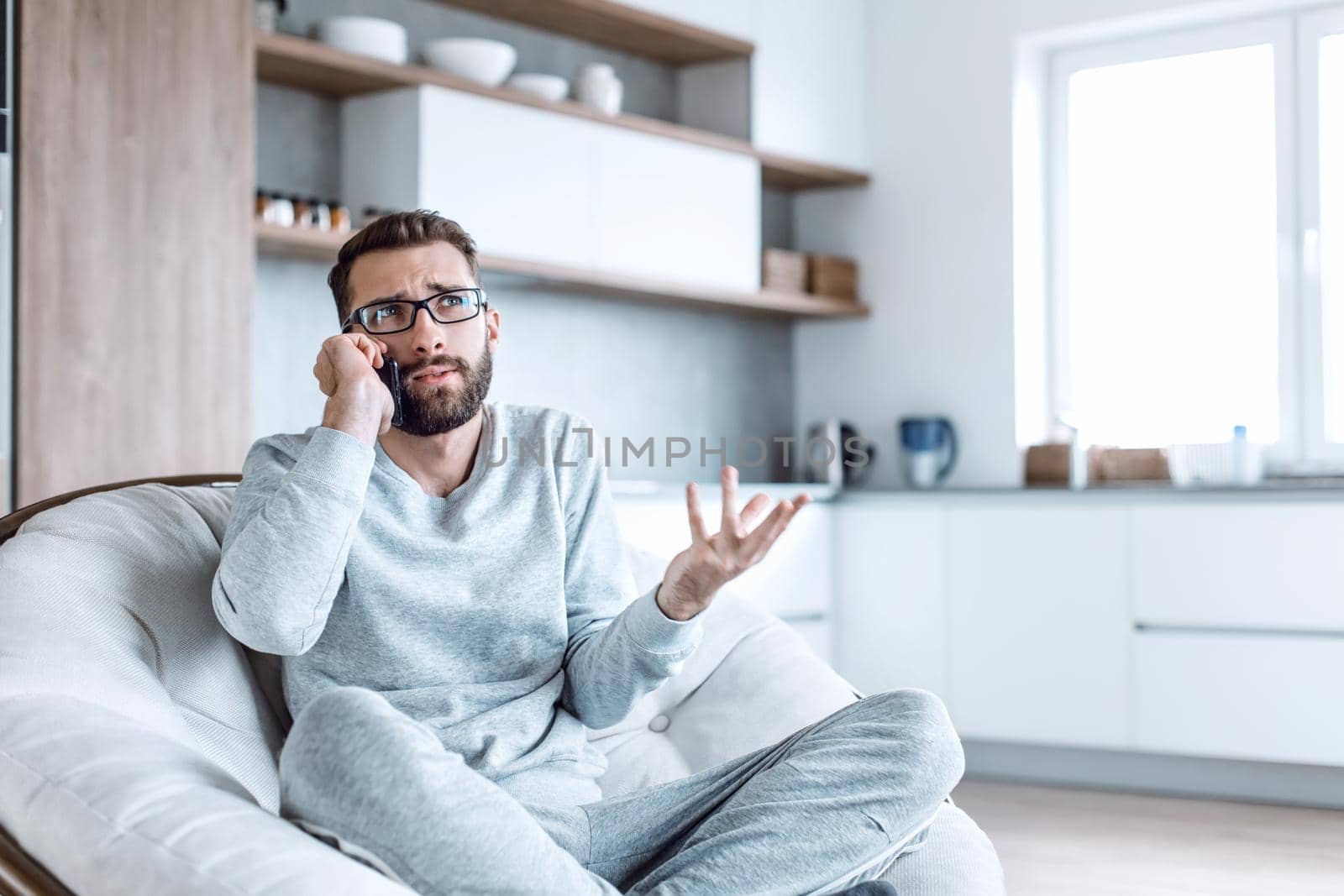 cheerful man talking on a mobile phone sitting in a comfortable chair. photo with copy space