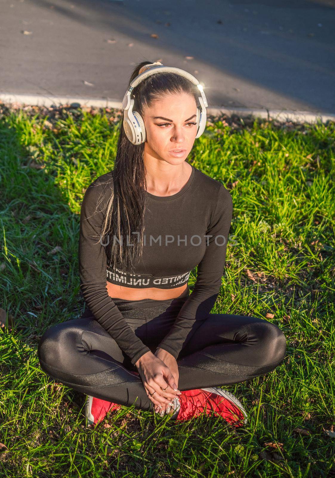 Fit girl listening to music./Fitness woman outdoors with headphones.