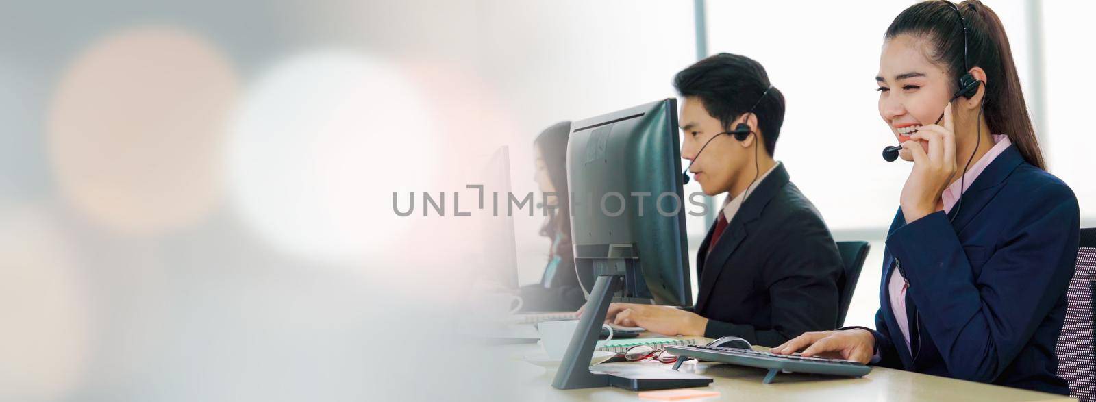 Business people wearing headset working in office in widen view to support remote customer or colleague. Call center, telemarketing, customer support agent provide service on telephone video call.