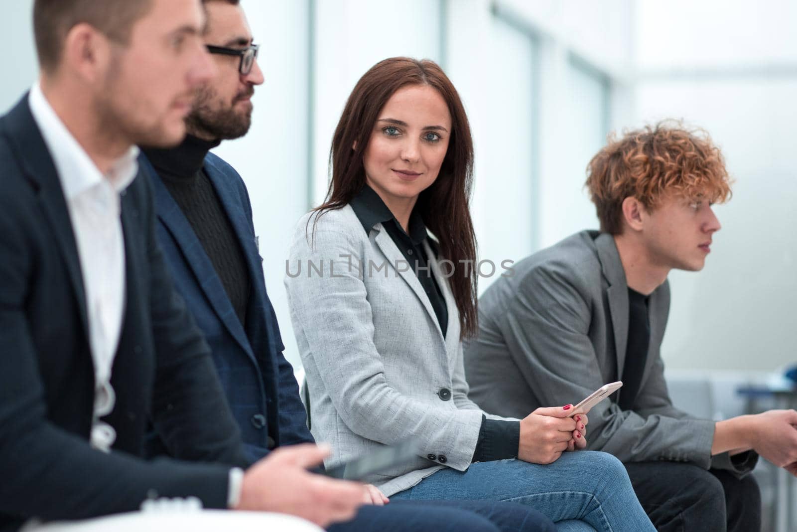 close up. a group of young people waiting, sitting in the queue