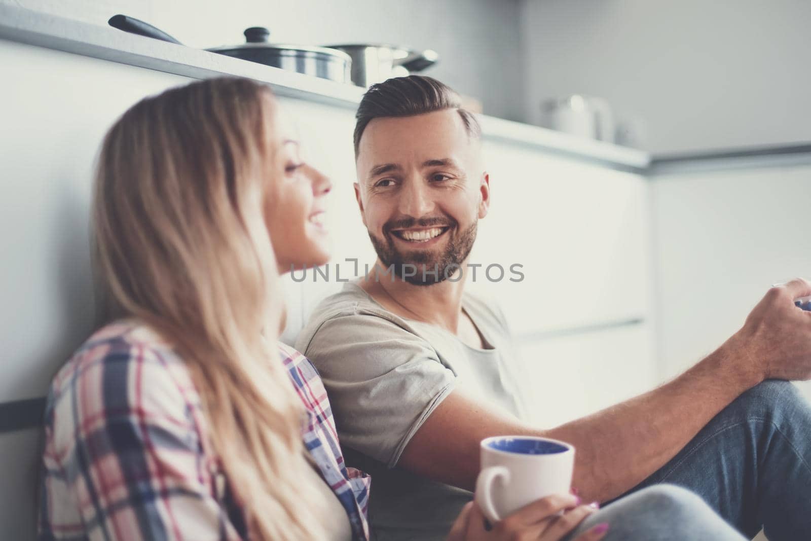 close up. loving couple talking, sitting in the kitchen on the floor