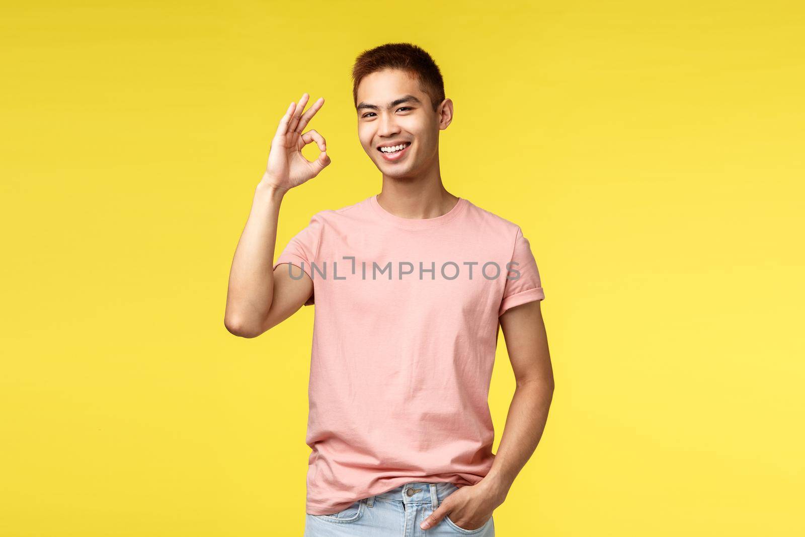 Lifestyle, travel and people concept. Nice quality, guarantee. Portrait of cheerful asian man showing okay, good sign and smiling joyfully, rate excellent product, approve and agree plan by Benzoix