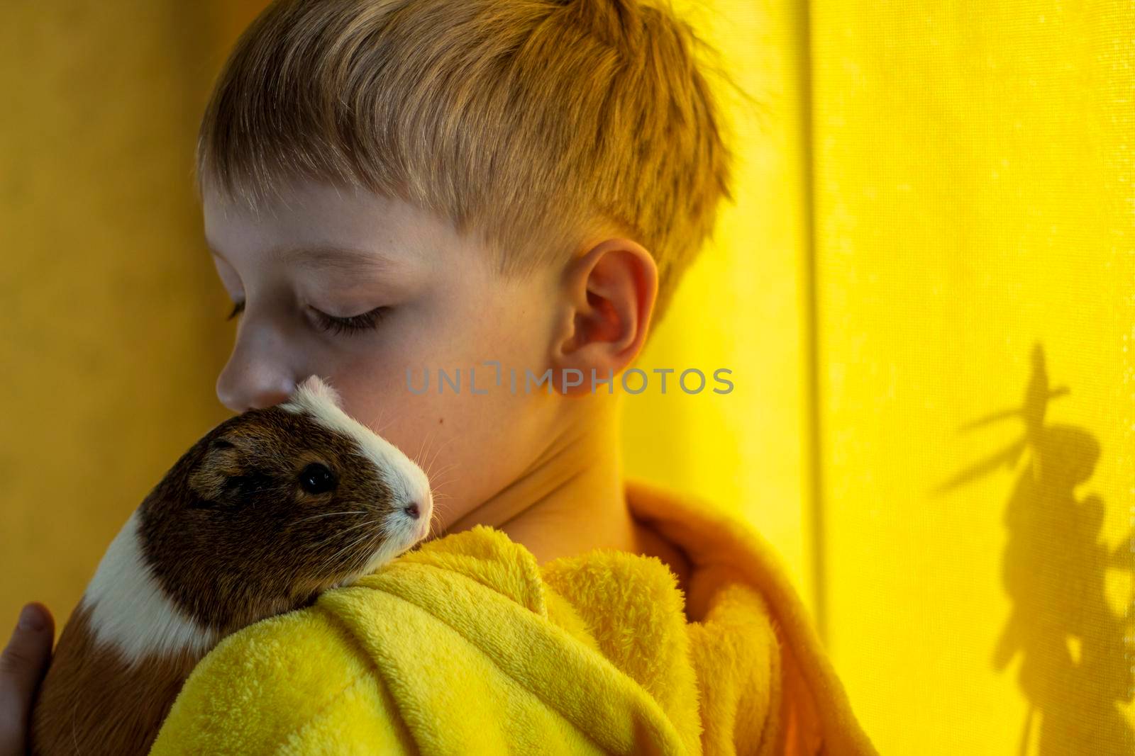 Young boy with guinea pig in yellow pigamas