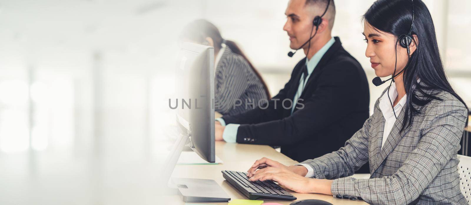 Business people wearing headset working in office to support remote customer or colleague. Call center, telemarketing, customer support agent provide service in broaden view .