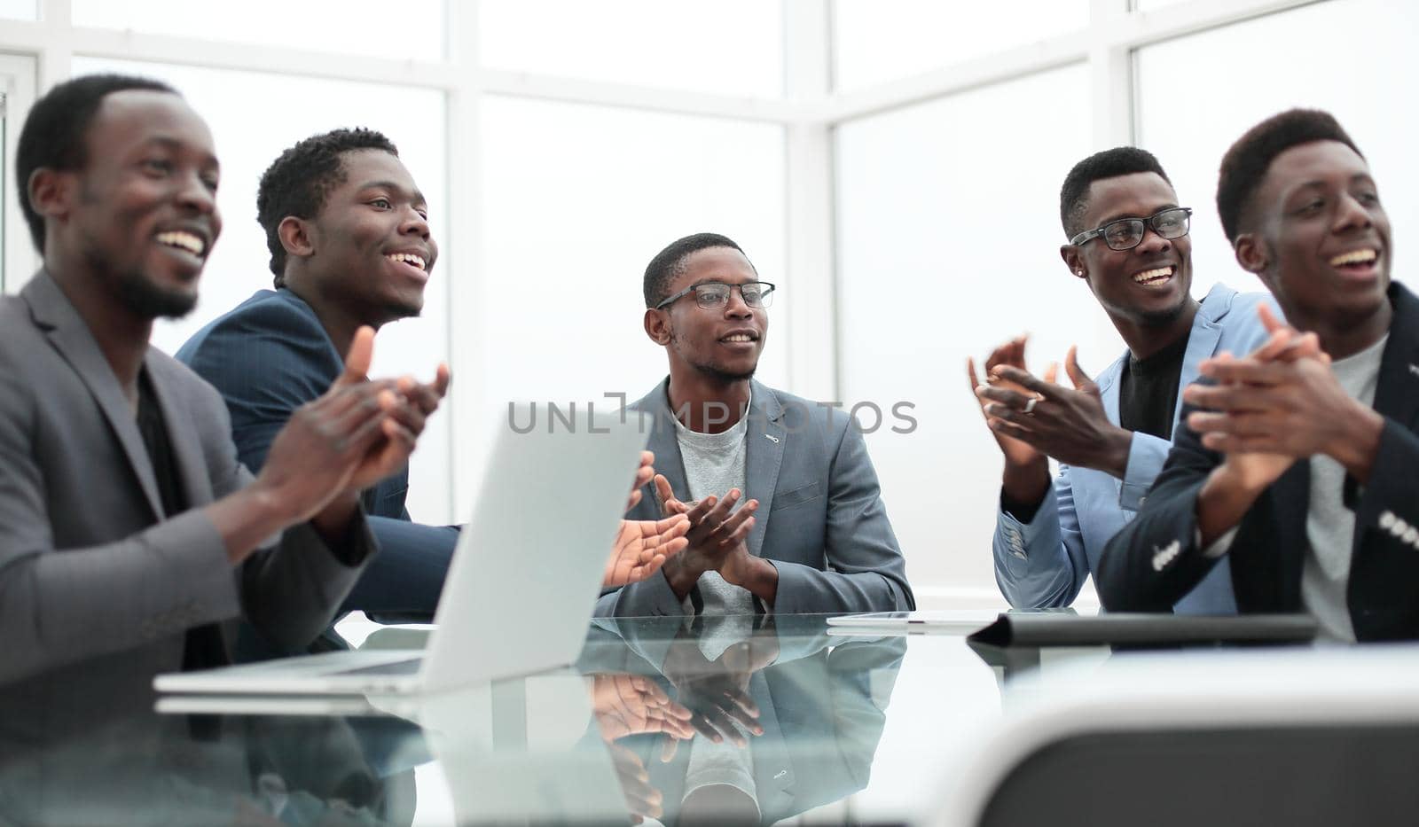 close up. business team applauds sitting at the office Desk.