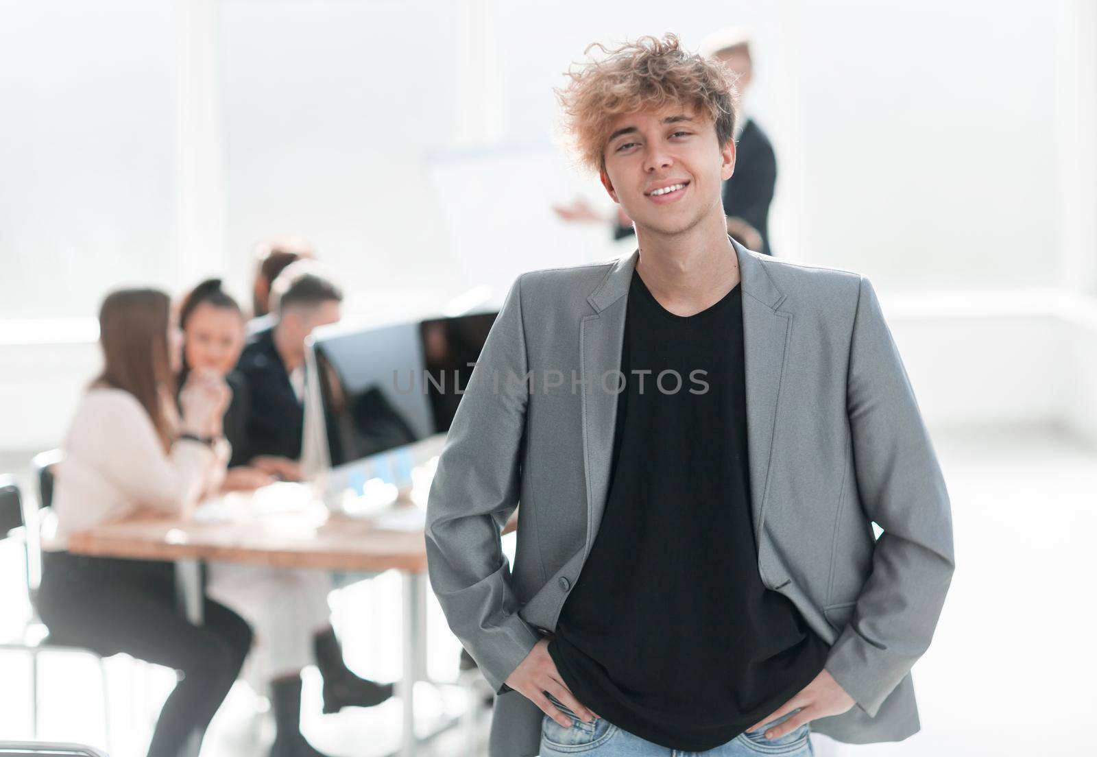 happy young employee standing in the office. business concept