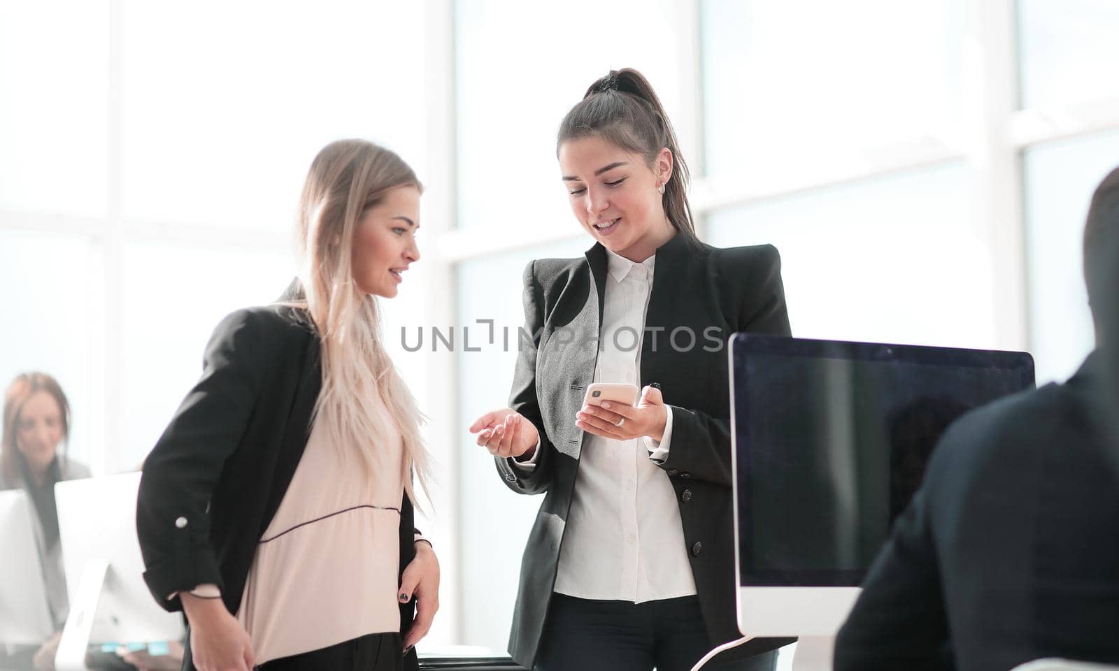 two young employees reading a message on their smartphone. by asdf
