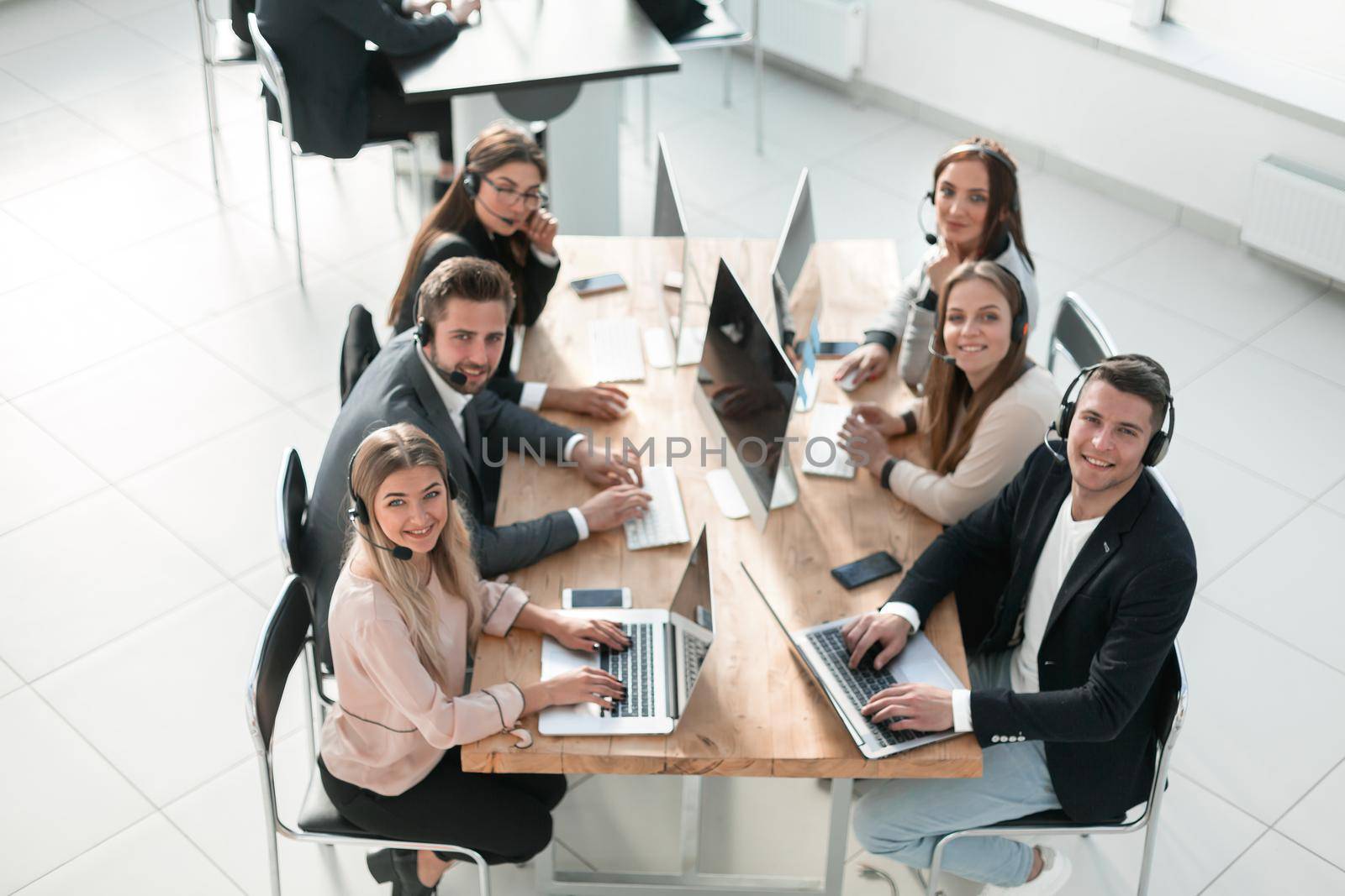 group of employees in a headset work in a modern office. by asdf