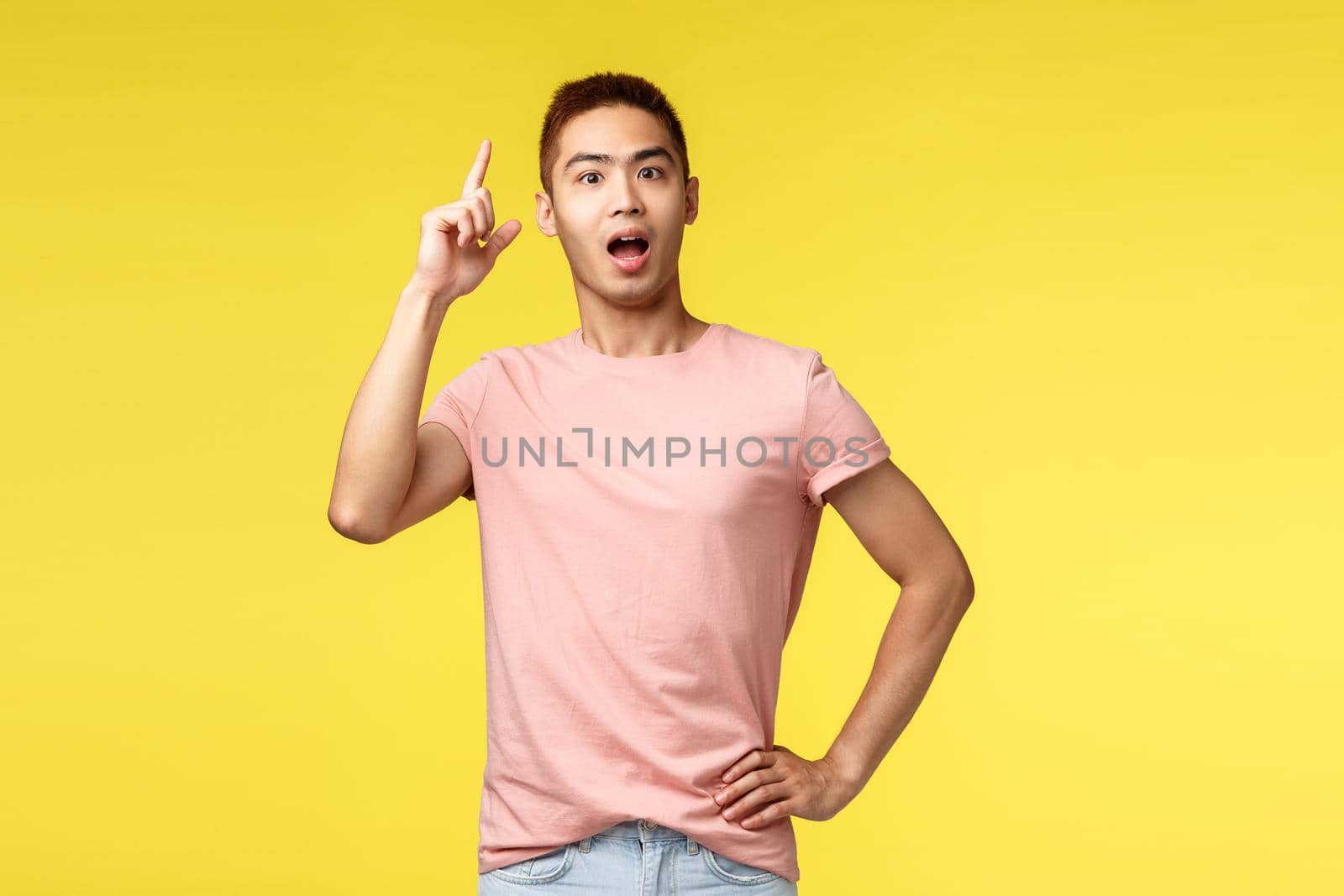 People, different emotions and lifestyle concept. Excited, smart asian guy in pink t-shirt, raising index finger tell suggestion, have plan, show eureka sign, have solution, solved problem.