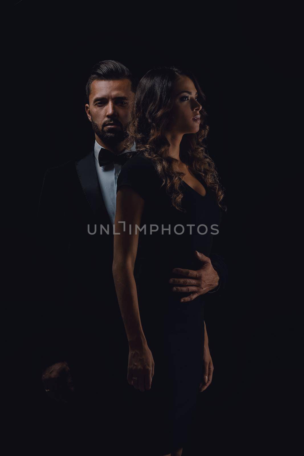 Full length picture of a young fashion couple standing on studio background.