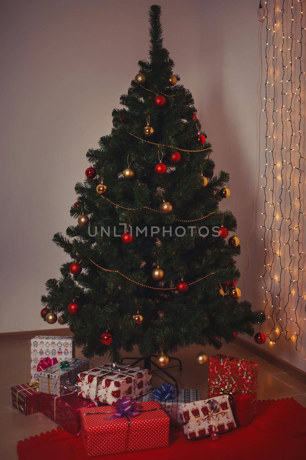 Christmas tree with Christmas toys. Gifts lying under the tree