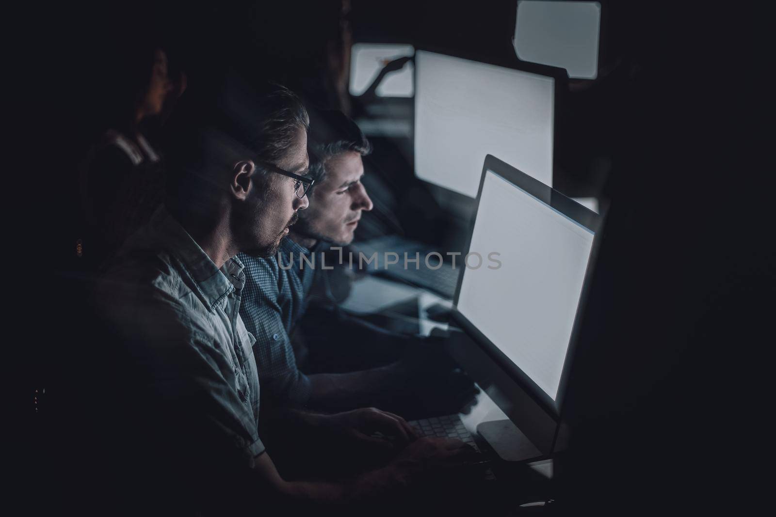 business team works on computers at night.the concept of overtime
