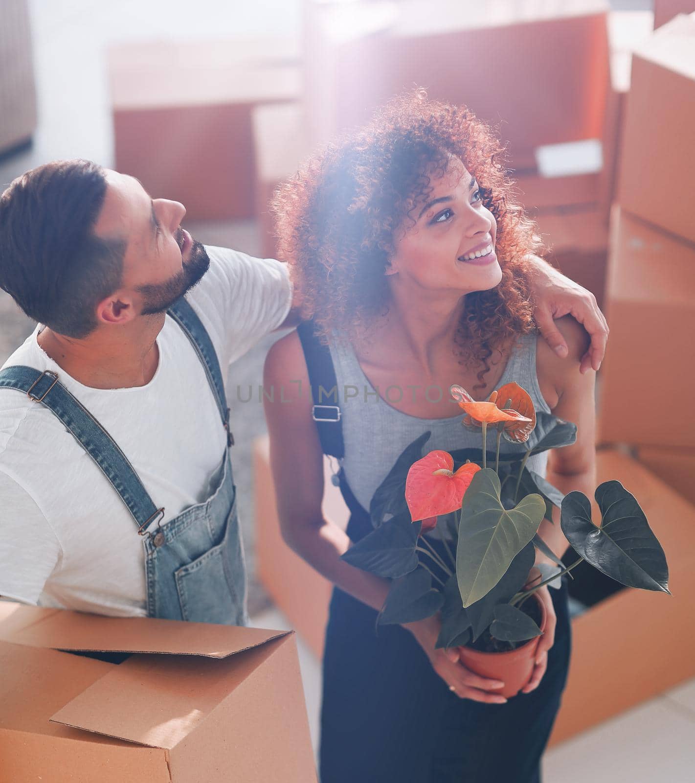 young couple is carrying boxes to a new home. Photo has a copy of space