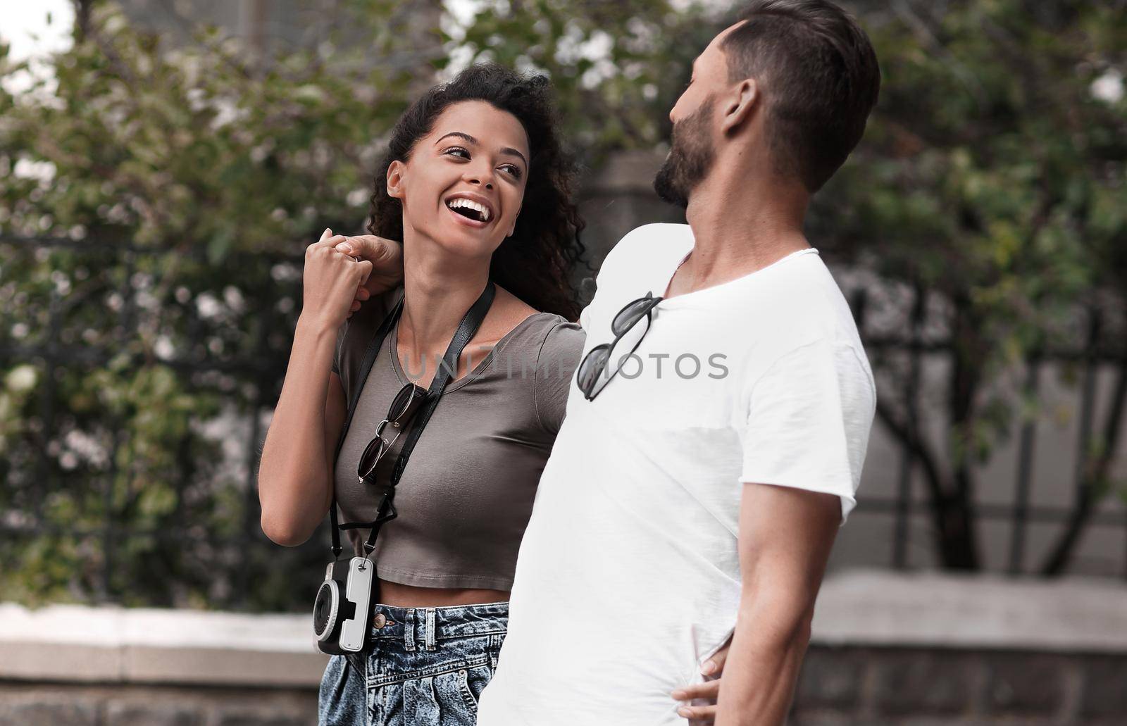 Cheerful young couple walking on urban street by asdf