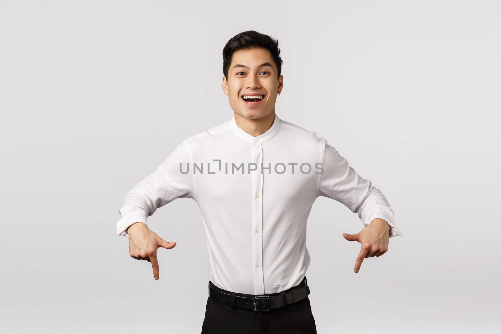 Happy and pleased successful asian male student, entrepreneur winning and asking check out something, smiling proud and delighted, looking camera, promoting cool product, white background.