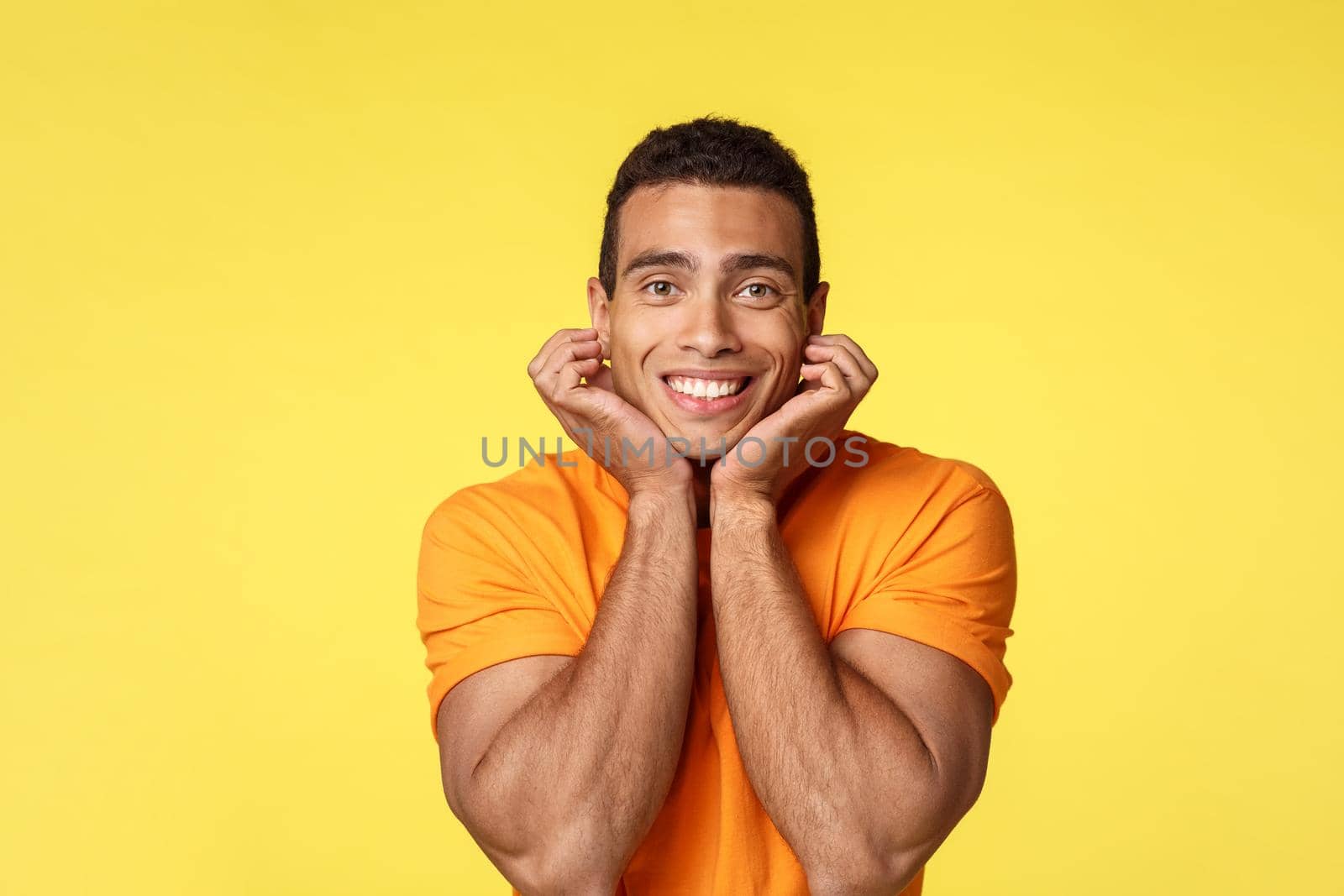 Romance and love concept. Romantic and tender silly handsome masculine man on date with boyfriend, leaning on palms sighing from affection, look with admiration and joy camera, yellow background by Benzoix