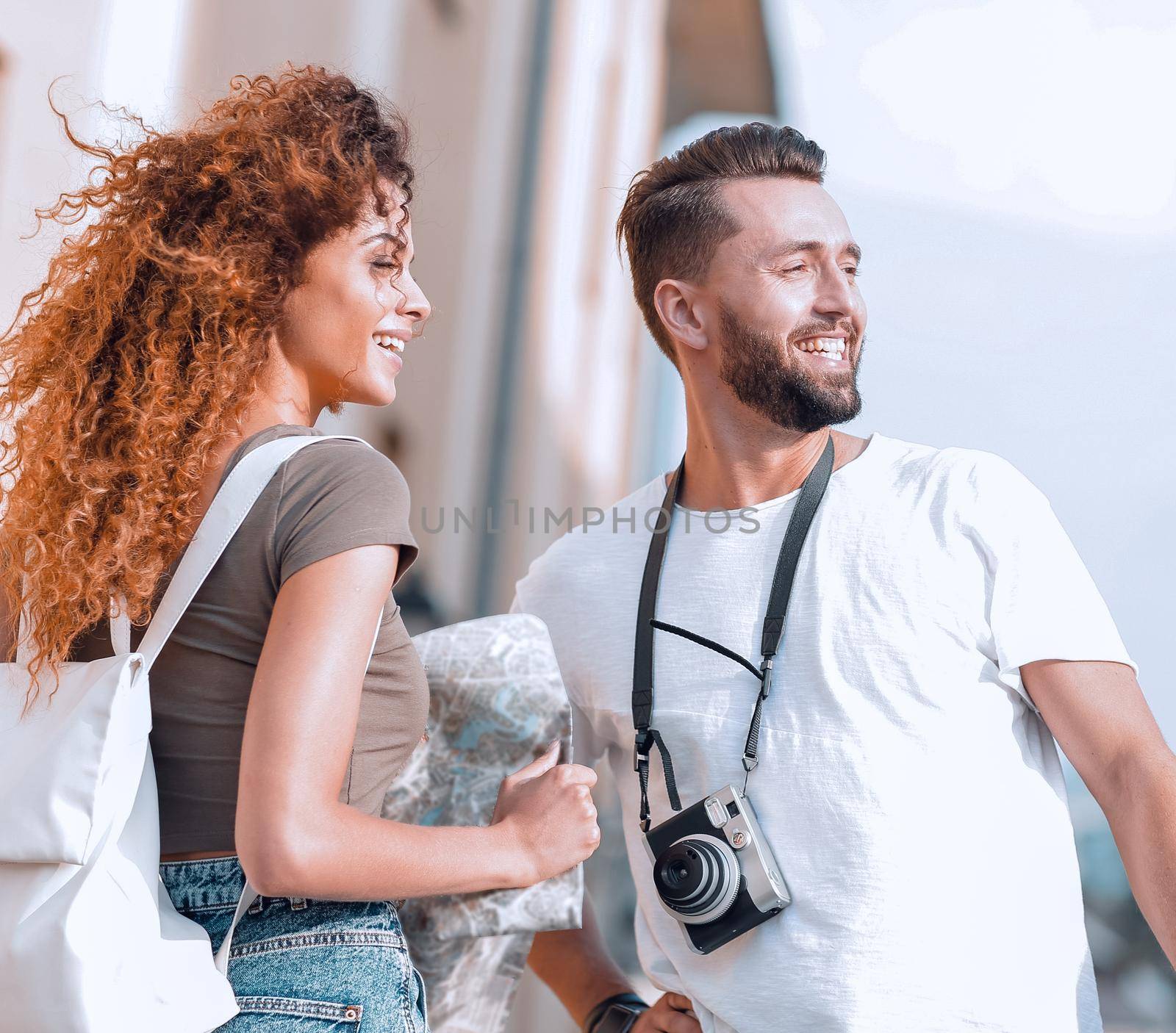 Young couple walking and looking at a guide while looking happy by asdf