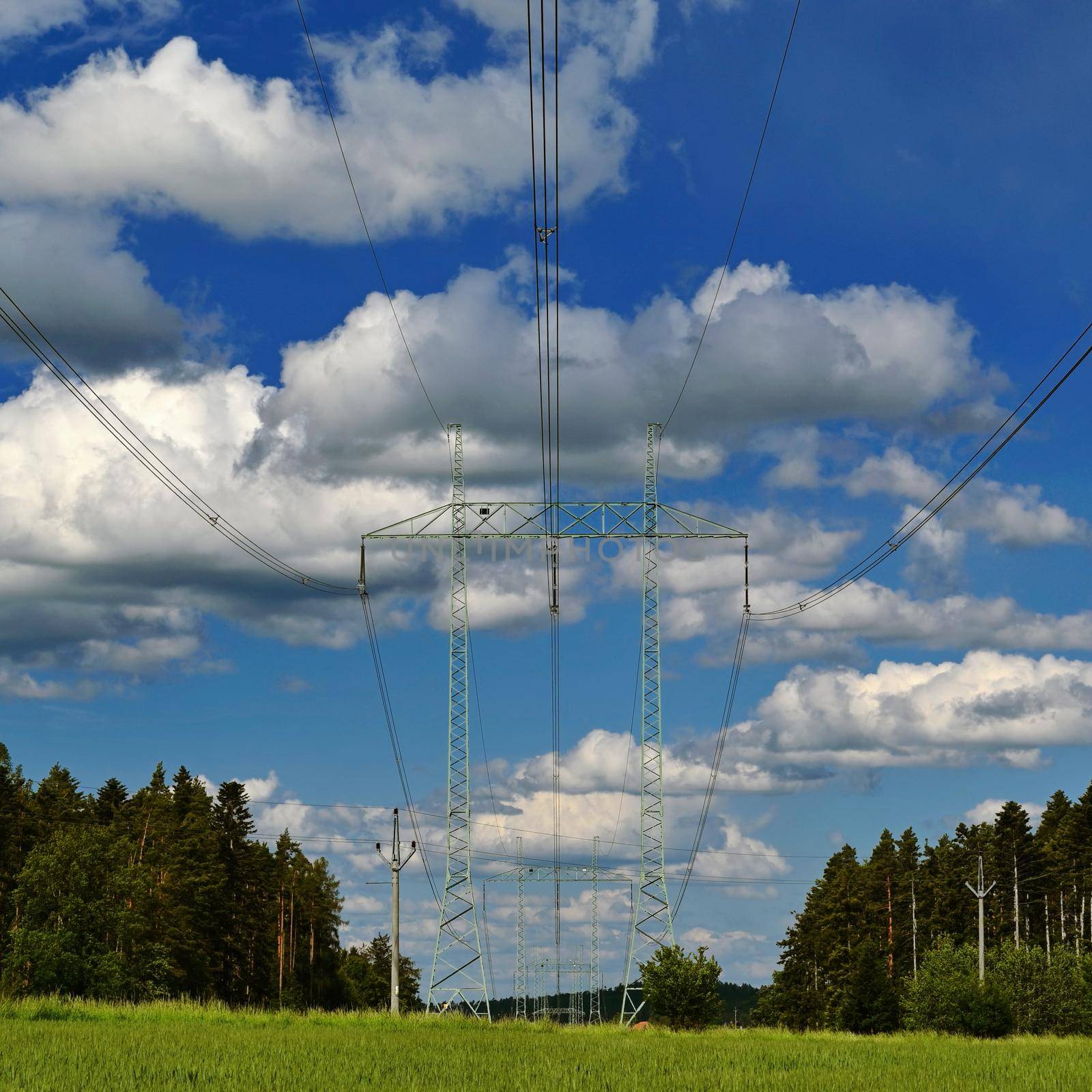 High voltage pylons - Blue sky with clouds and sun in nature. Concept for technology and industry. Further rising electricity and energy prices - the energy crisis caused by the war between Russia and Ukraine.  by Montypeter