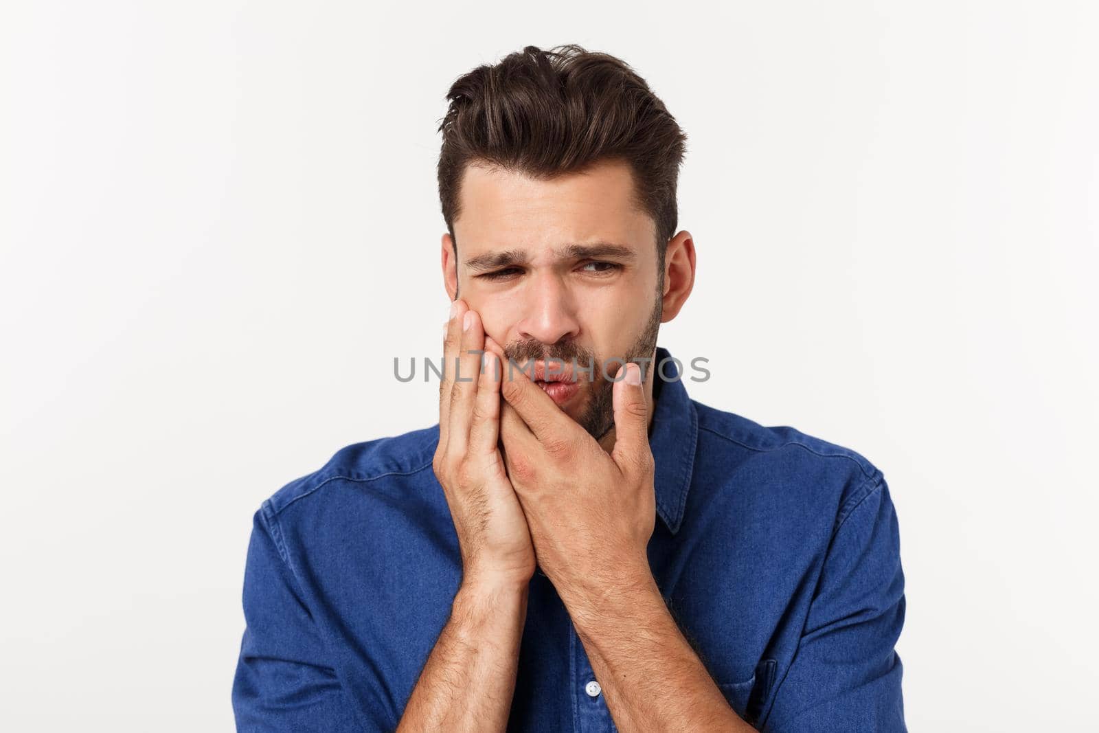 Close up portrait of disappointed stressed bearded young man in shirt over white background