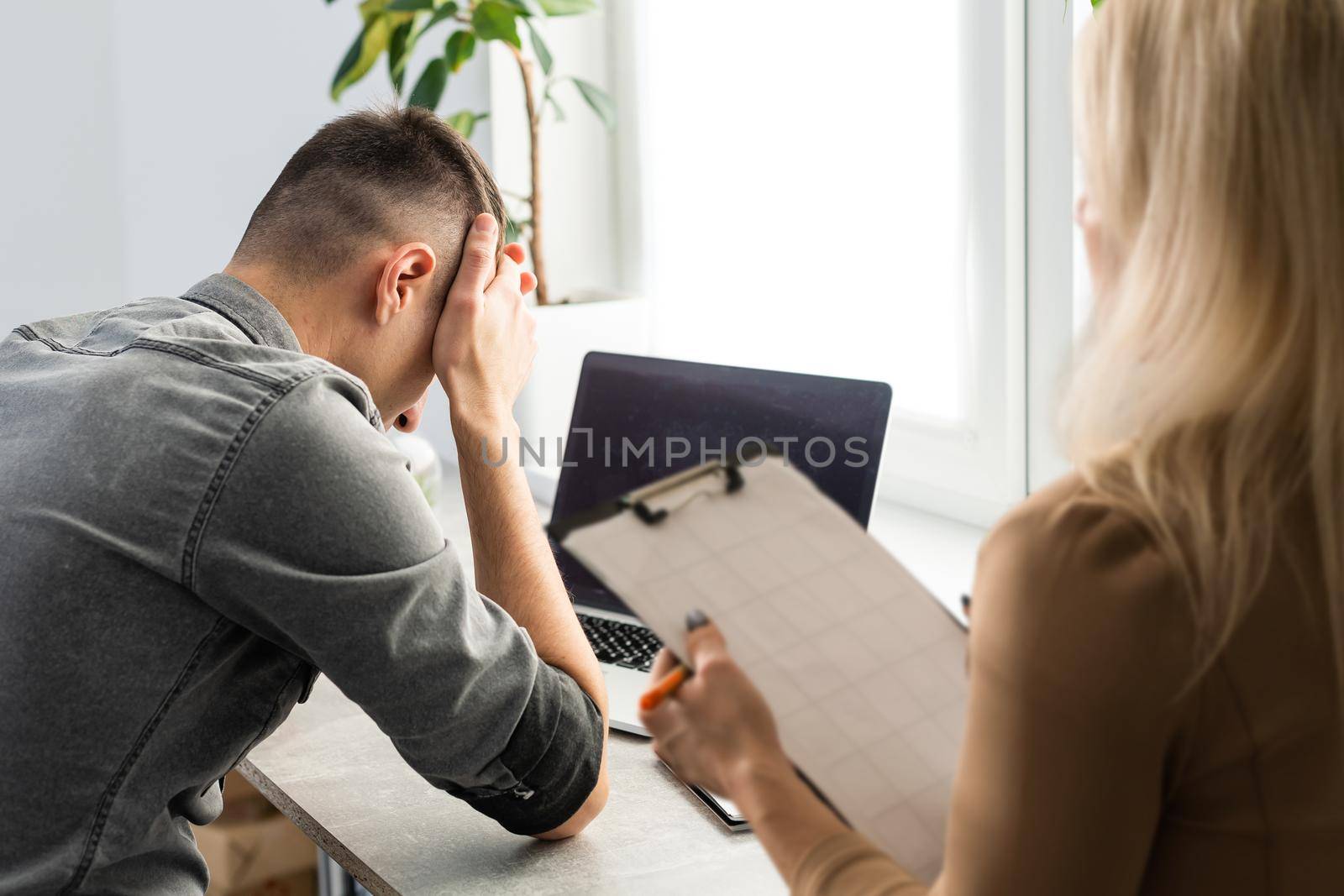 woman psychologist listening to the businessman client sitting during psychological session.
