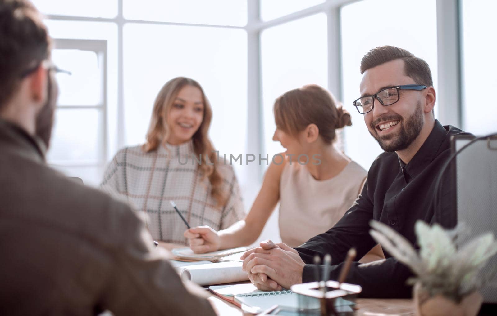 smiling businessman at a working meeting in the office by asdf