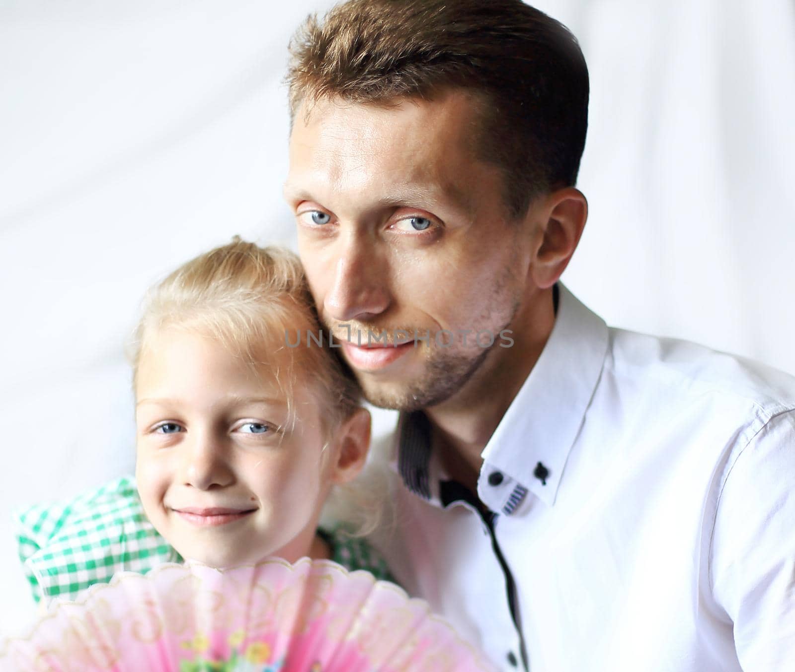 portrait of a loving father and daughter with a fan on a light background. by SmartPhotoLab