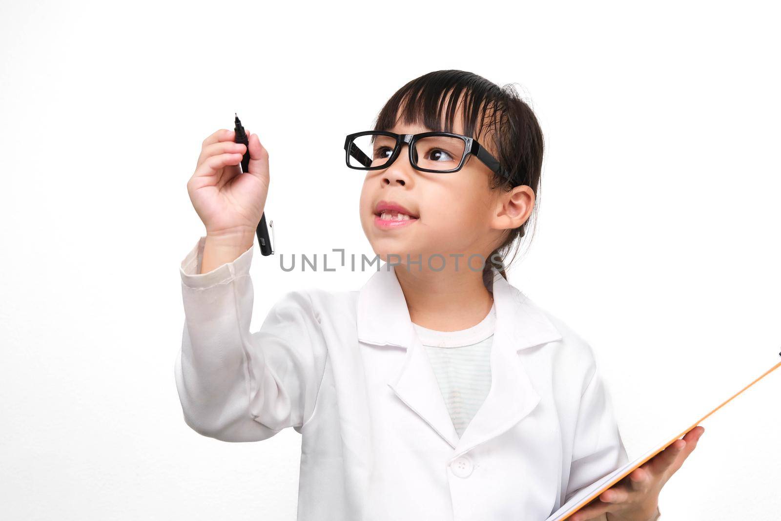 Portrait of a little scientist holding a clipboard with a pen thinking on a white background. A little girl role playing in a doctor or science costume. by TEERASAK