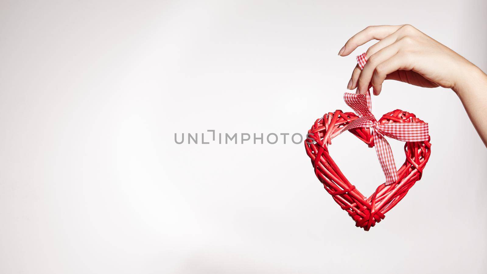 Beautiful Woman Hand Keep Wooden Heart. Heart Isolated on White Background with Copy Space. Love, Family. Valentine's Day concept.