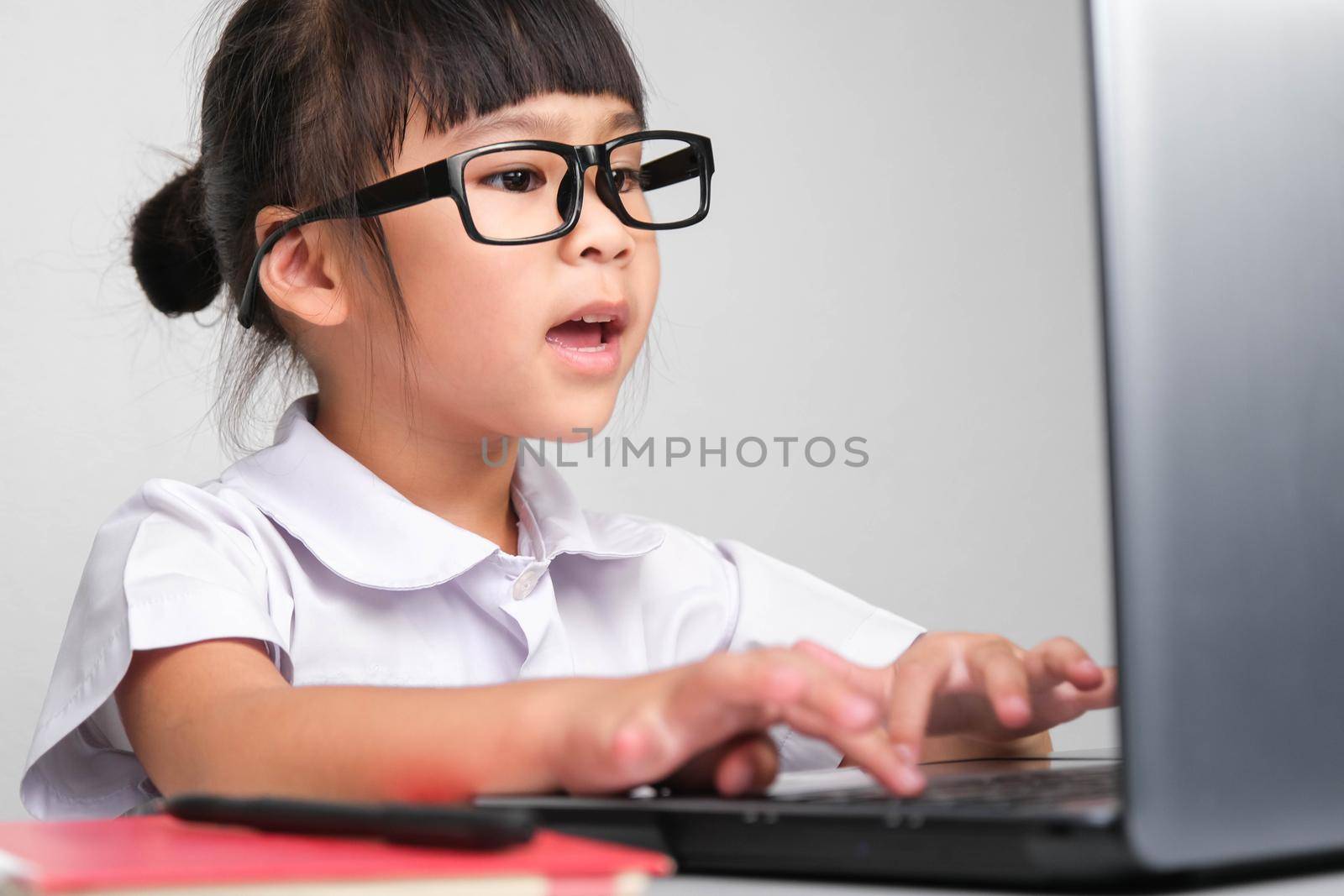 Stressed little businesswoman with laptop working in office. children and business Concepts by TEERASAK