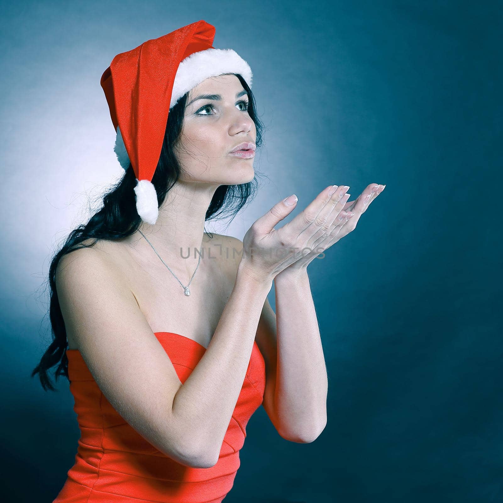 beautiful young woman in costume of Santa Claus showing to copy space. isolated on black.