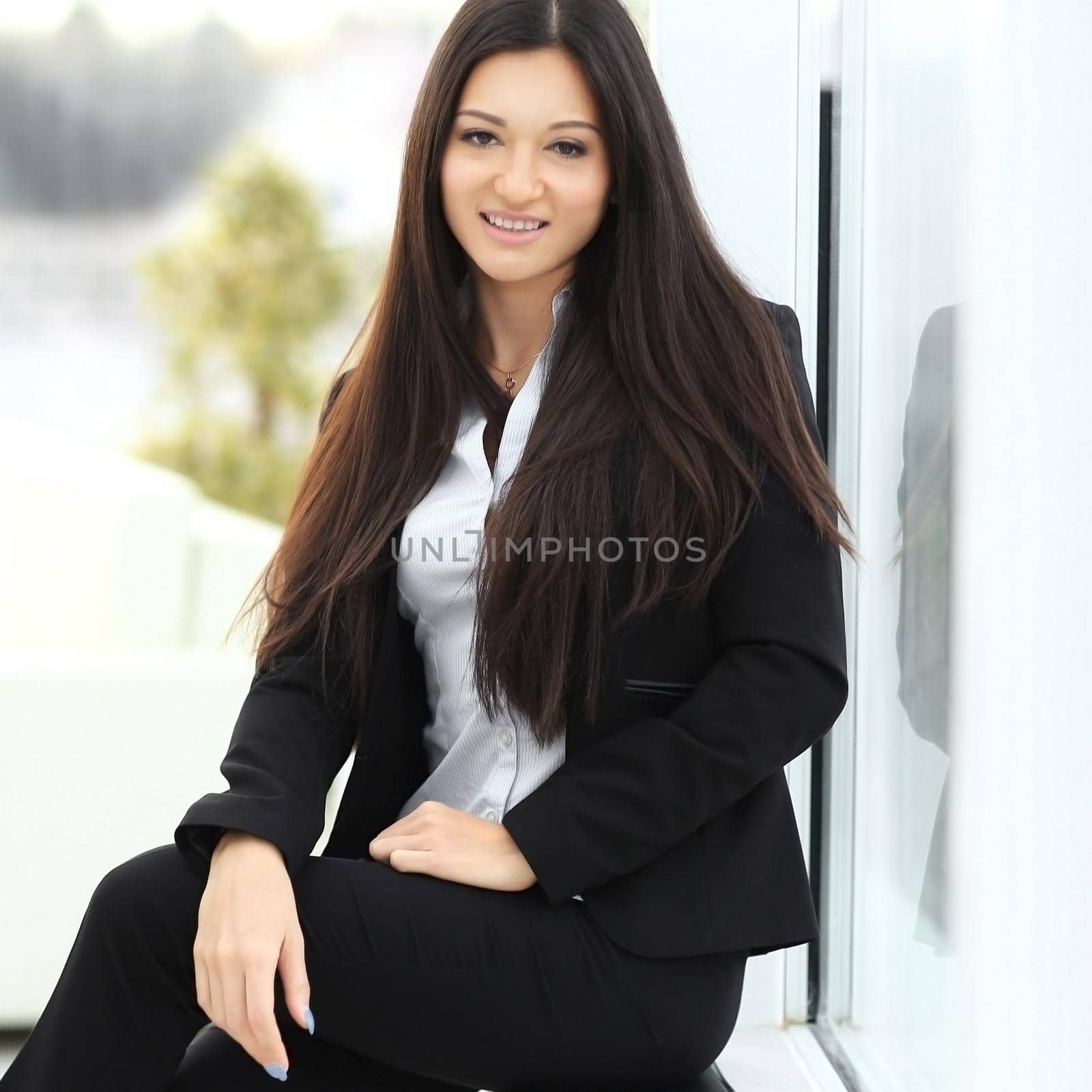 young employee sitting near a window in the office .photo with place for text