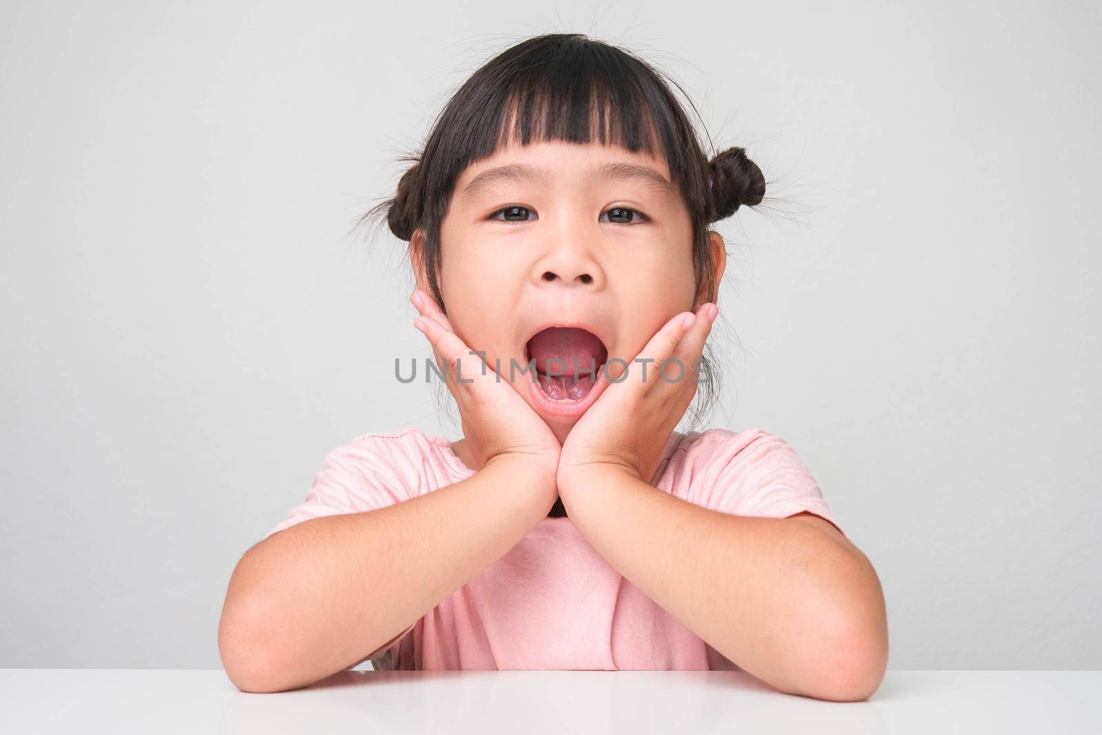 Cute little girl making a gesture to look attractive, cute, healthy, cheerful looking at the camera, isolated on white background. childhood happiness