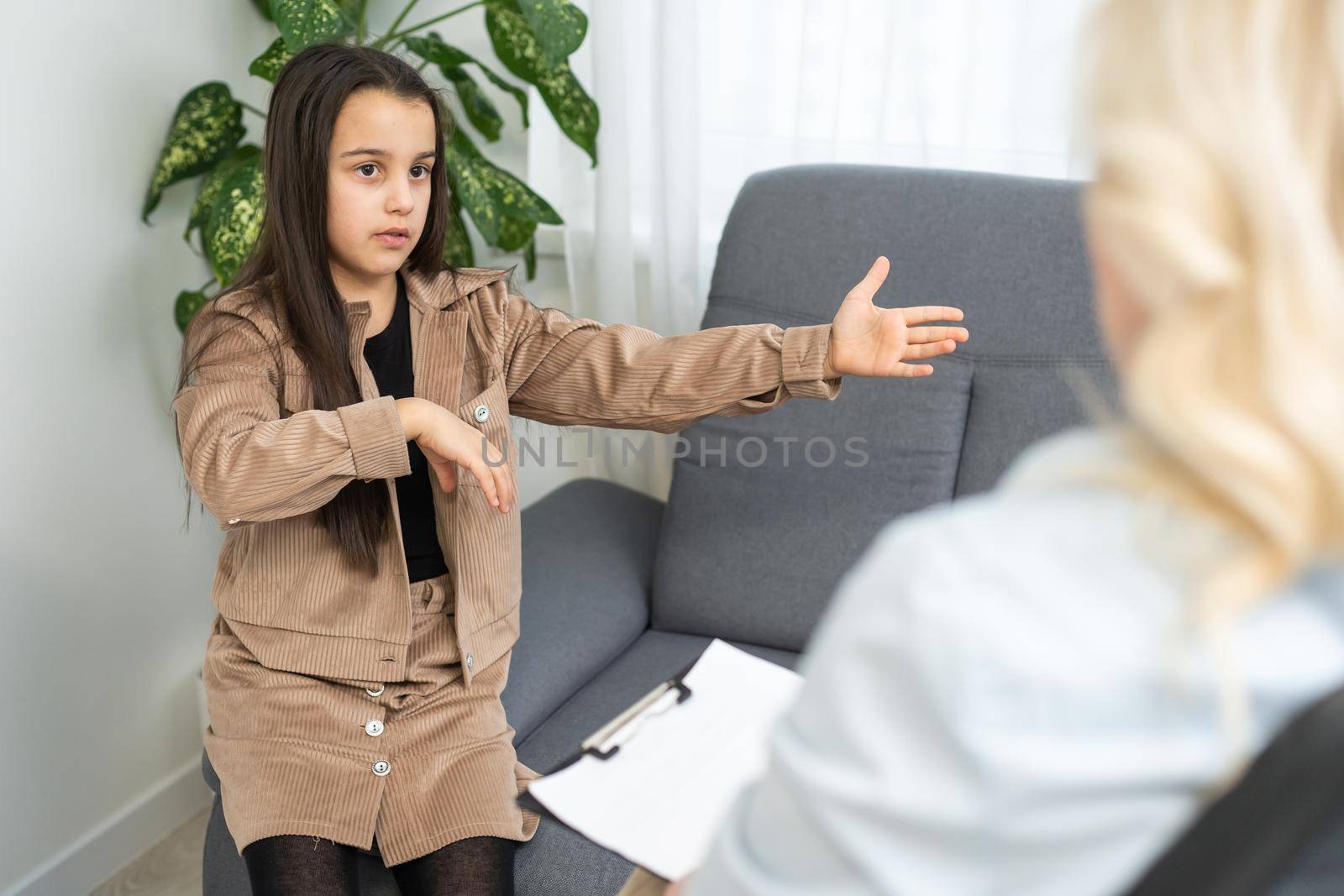Female psychologist working with little girl at home.