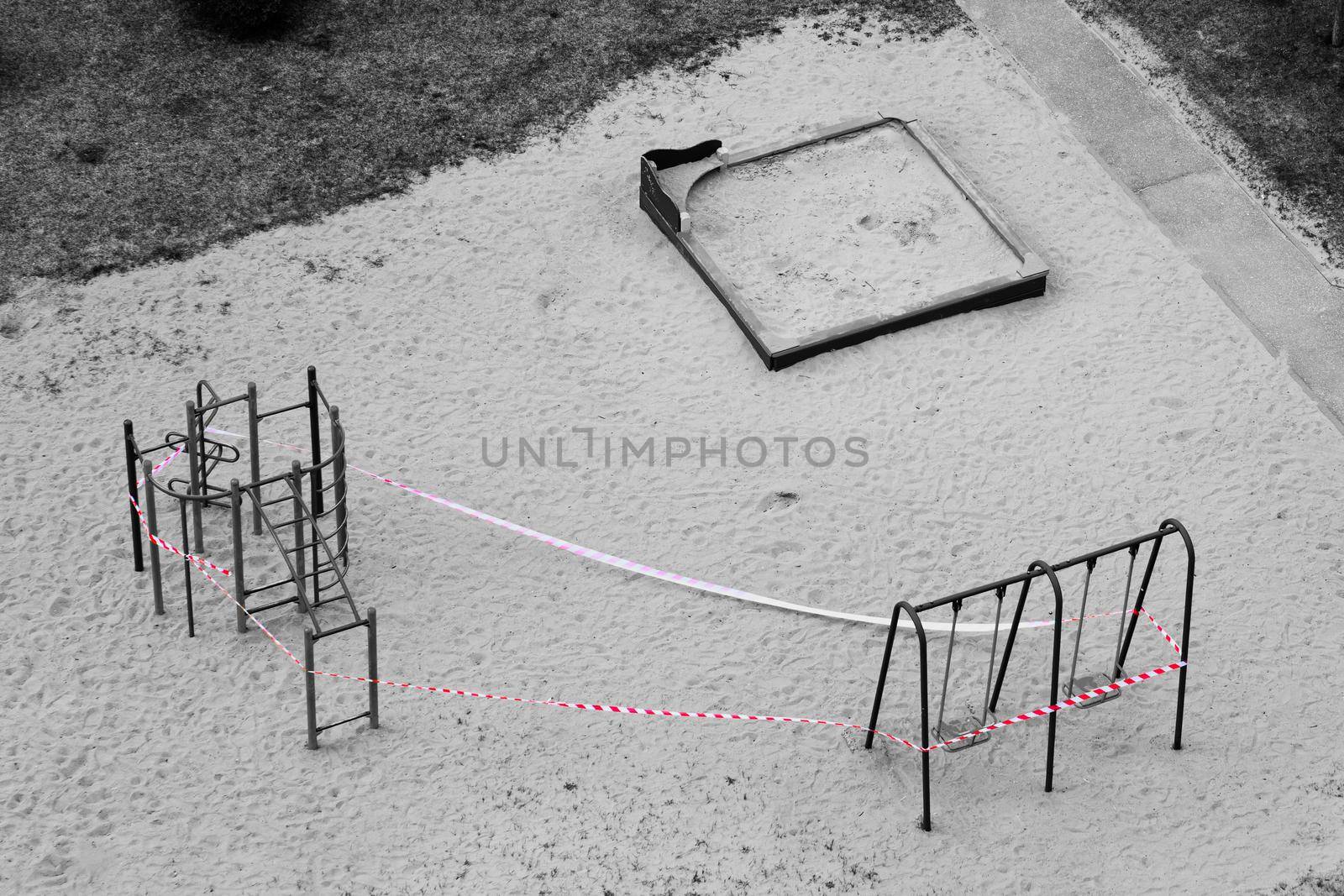 Playground equipment is closed due to Covid-19. Uninhabited place during a pandemic. Red stop ribbon on teeter by MarinaFrost