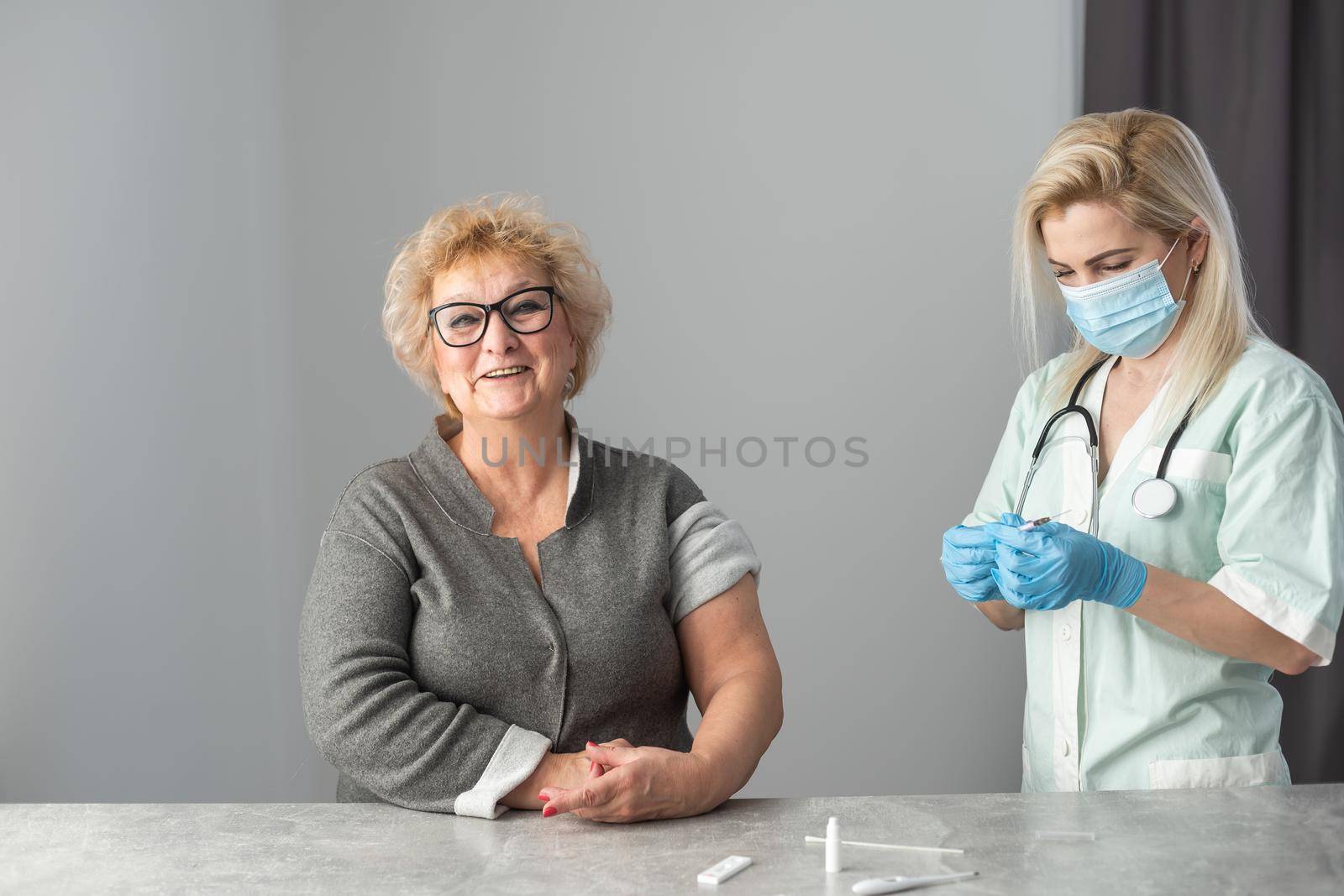 Senior vaccination concept. Elderly getting immune vaccine at arm for flu shot, pneumonia, and shingles in hospital by nurse. Doctor giving an injection to older people patient in clinic.