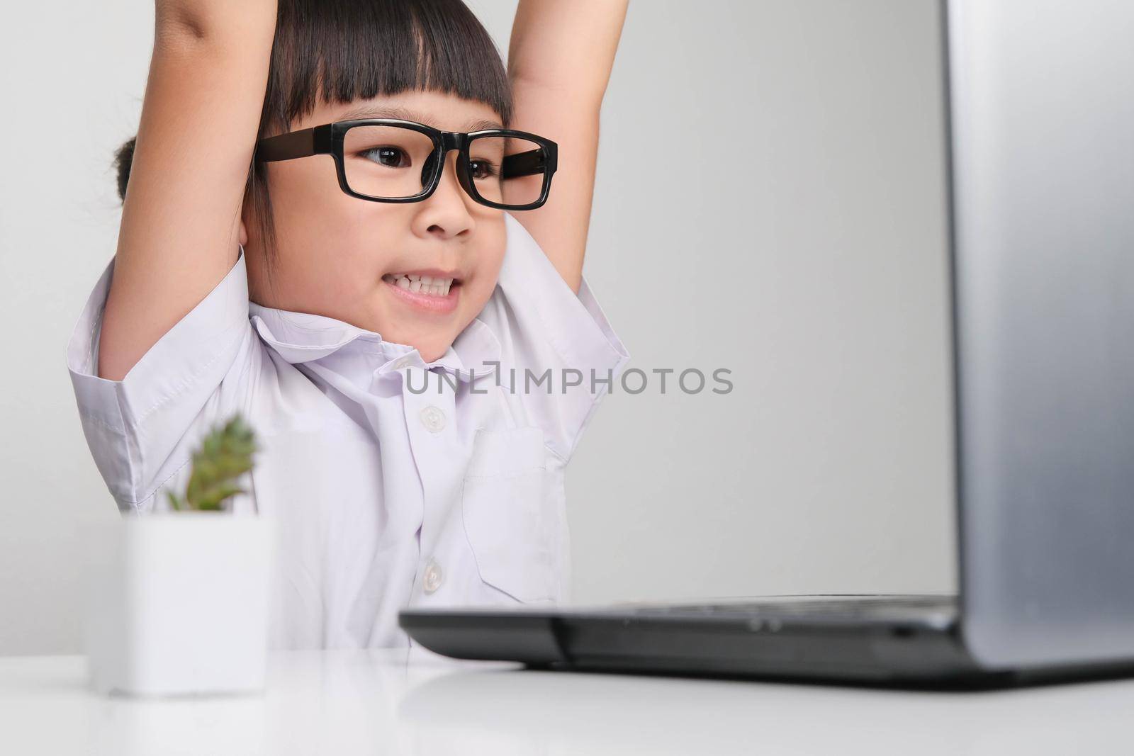 Happy little businesswoman with laptop working in office. Children, Business and Success Concepts by TEERASAK