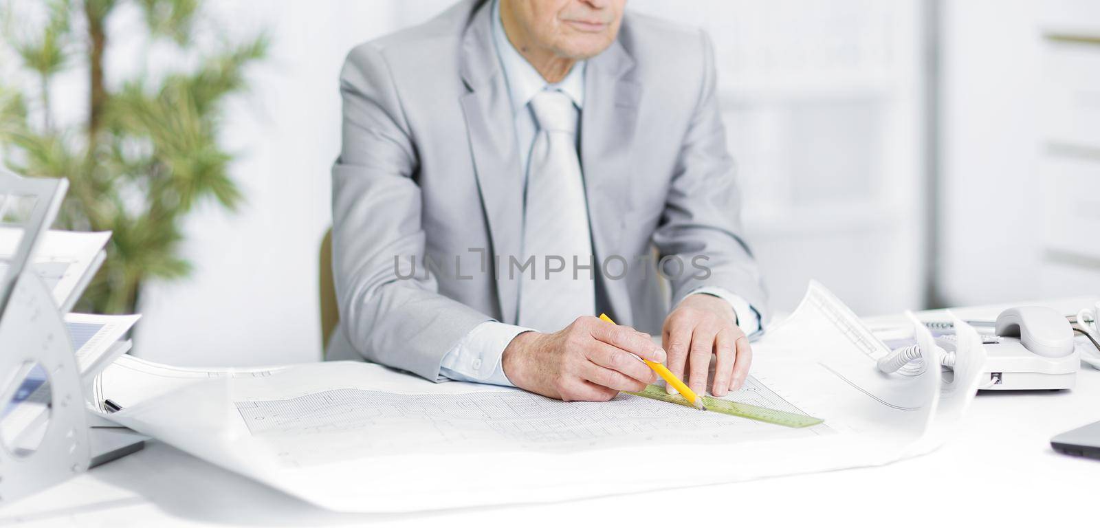 engineer works with drawings sitting at his Desk by SmartPhotoLab