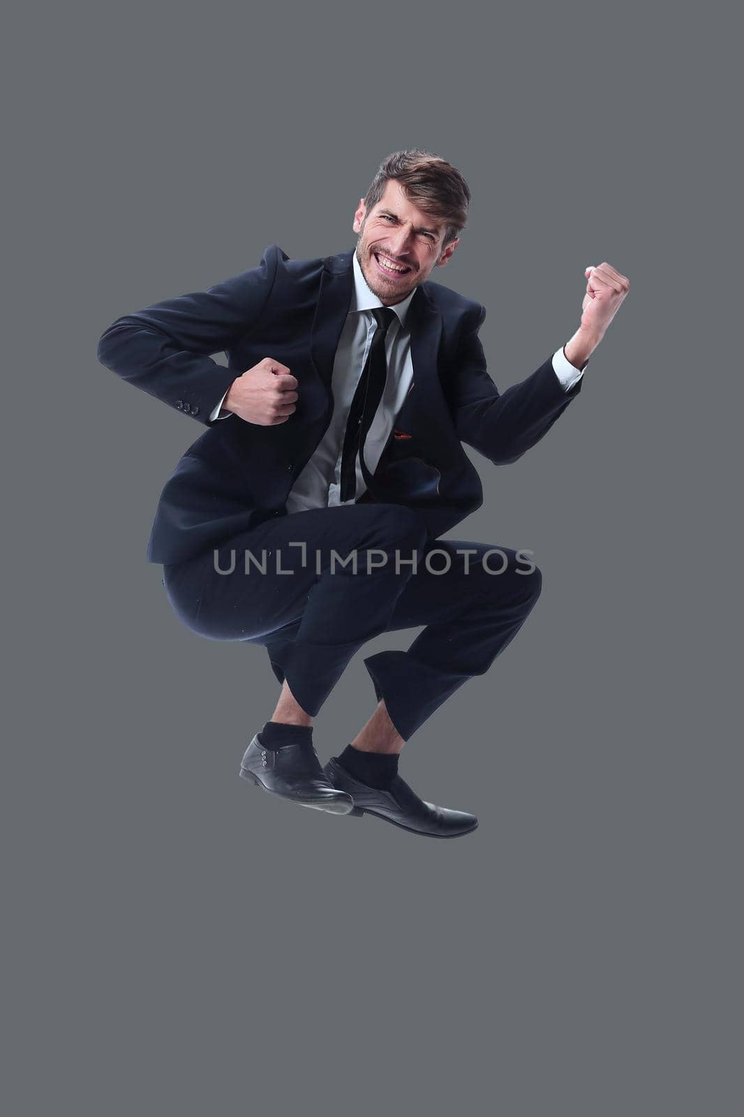in full growth. happy young businessman. isolated on white background.