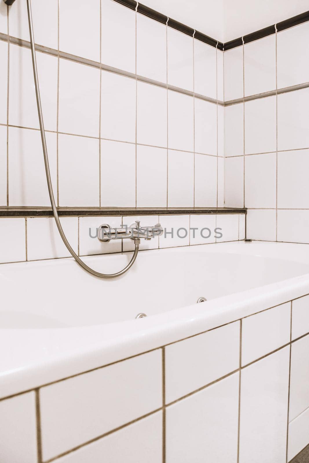 White and black tiled bathroom with white bath