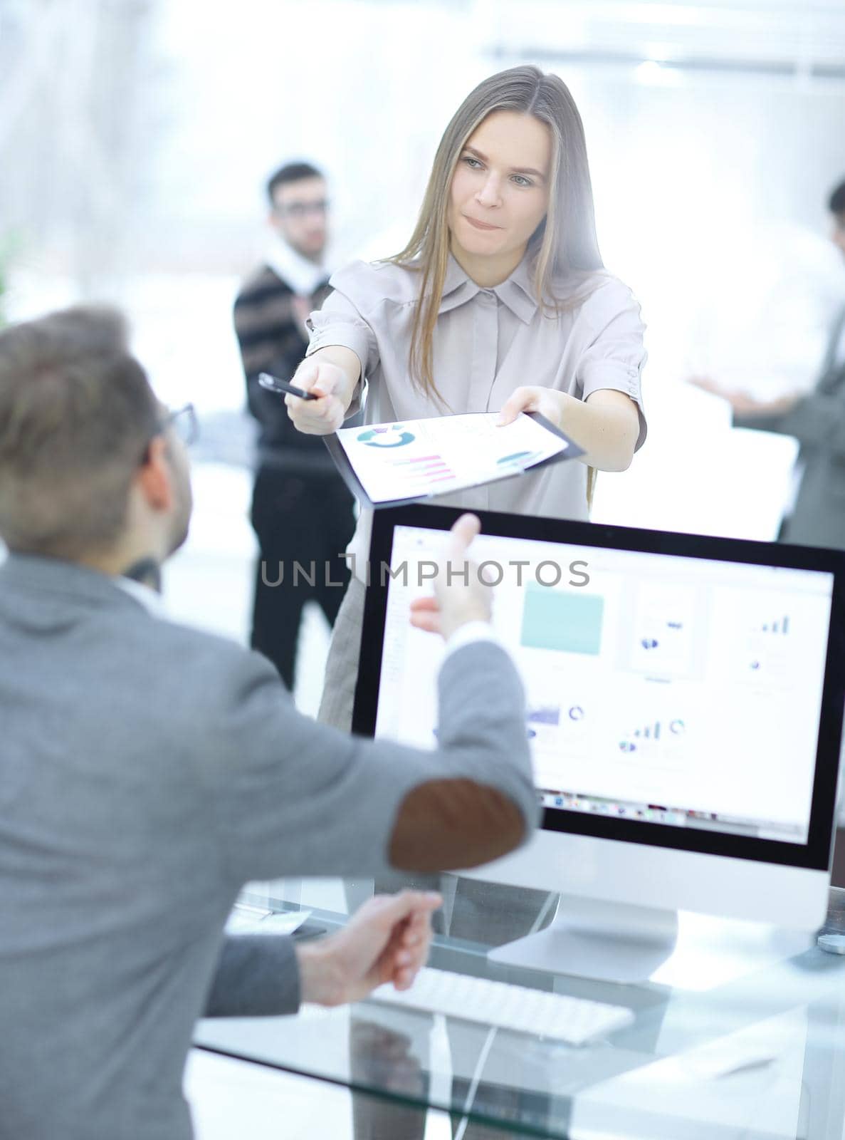 female assistant gives the employee a financial document. by SmartPhotoLab