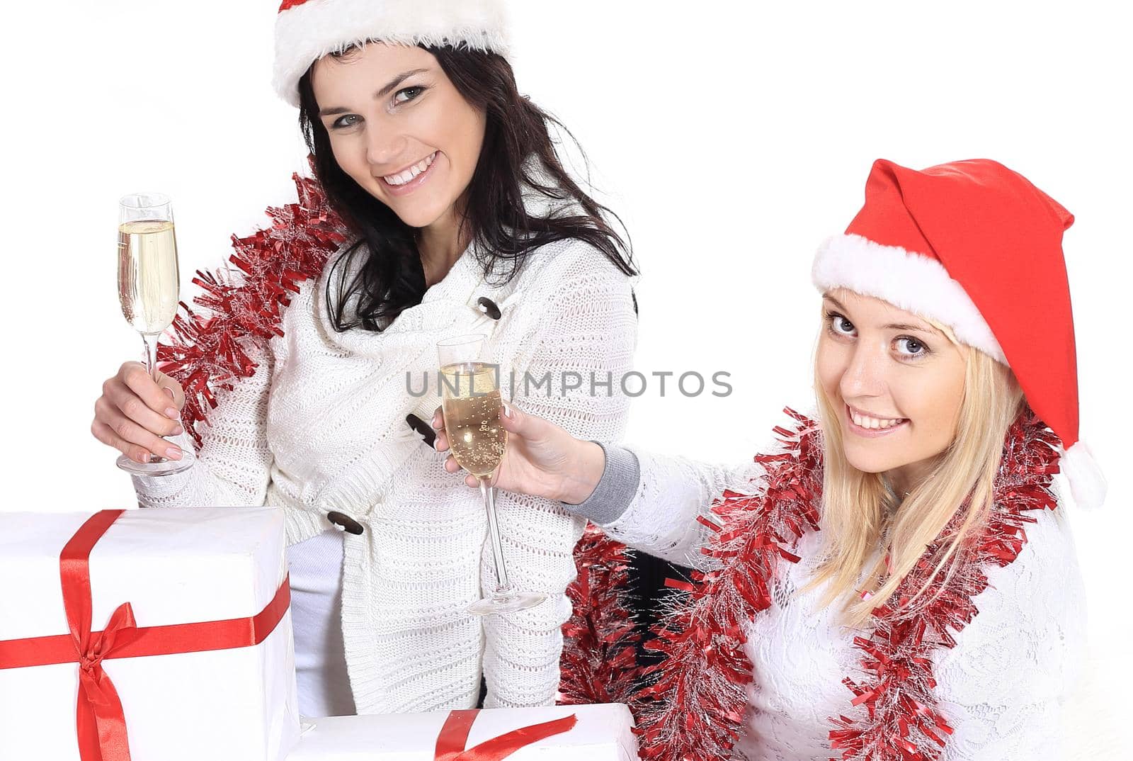 closeup.three young women in hats of Santa Claus with Christmas gifts and glasses of champagne by SmartPhotoLab