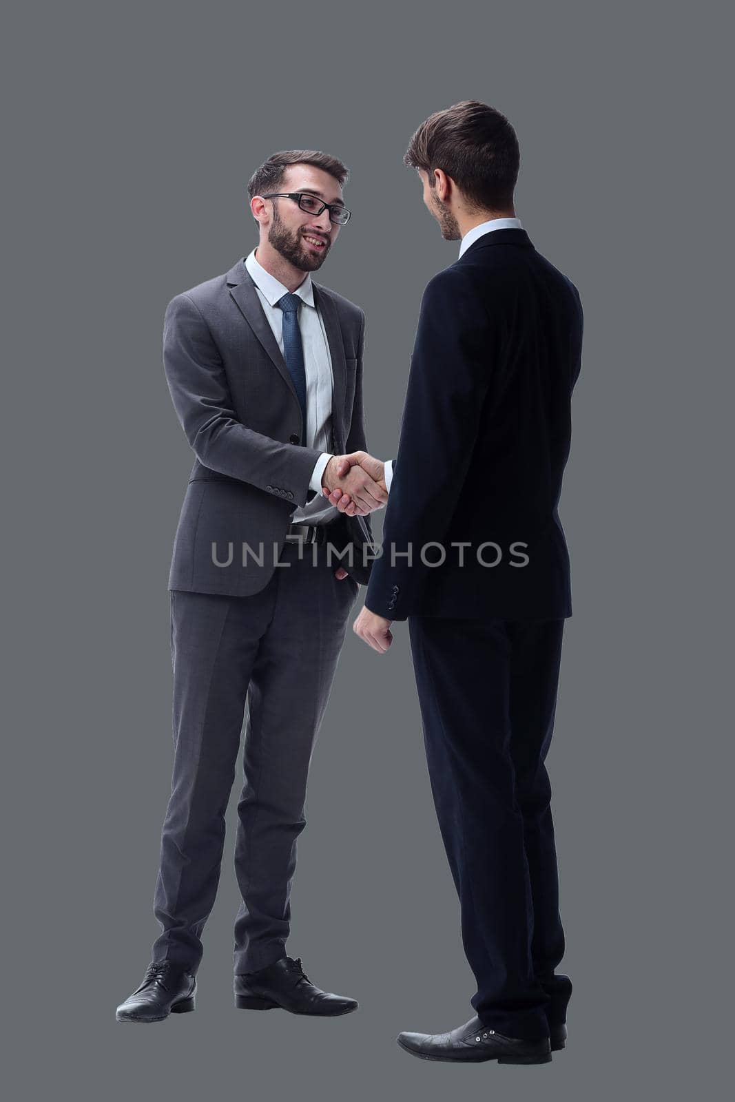 in full growth. business people shaking hands. isolated on white background