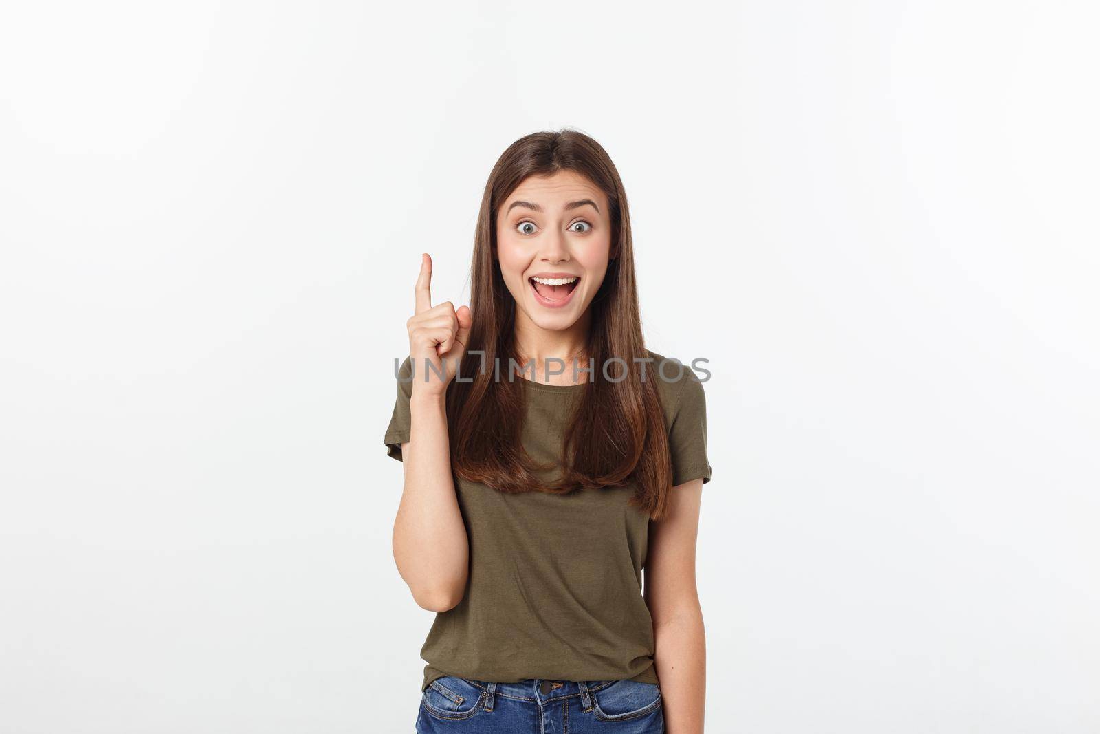 Portrait happy and surprised young lady standing isolated over grey background. Looking camera pointing