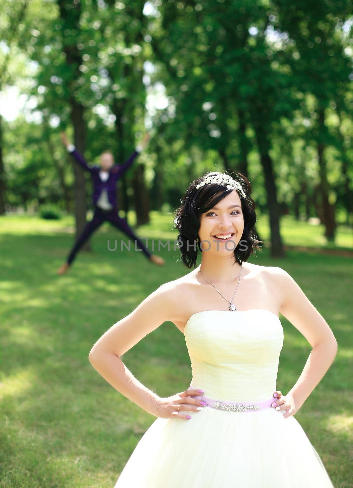 happy bride standing in a Park on a summer day by SmartPhotoLab