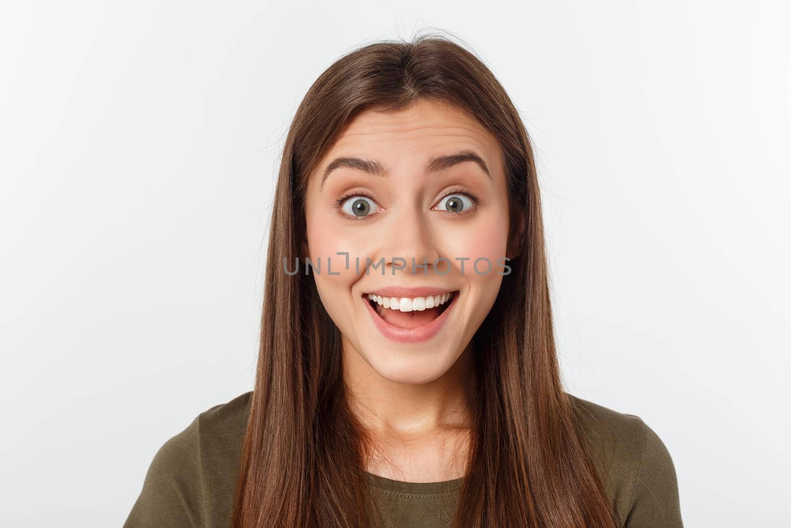 Close-up portrait of surprised beautiful girl holding her head in amazement and open-mouthed. Over white background.