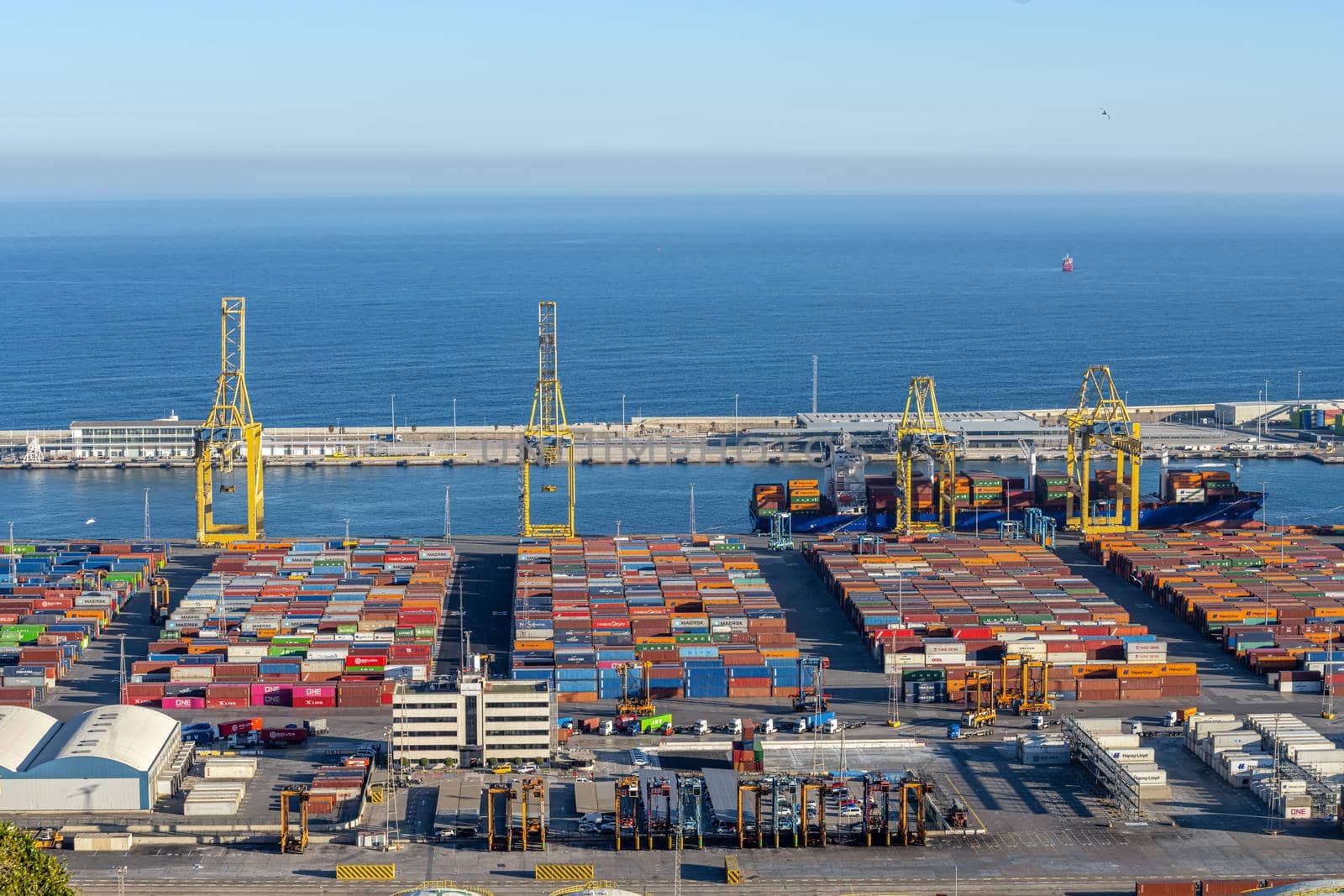 The commercial harbour of Barcelona with containers and cranes by elxeneize