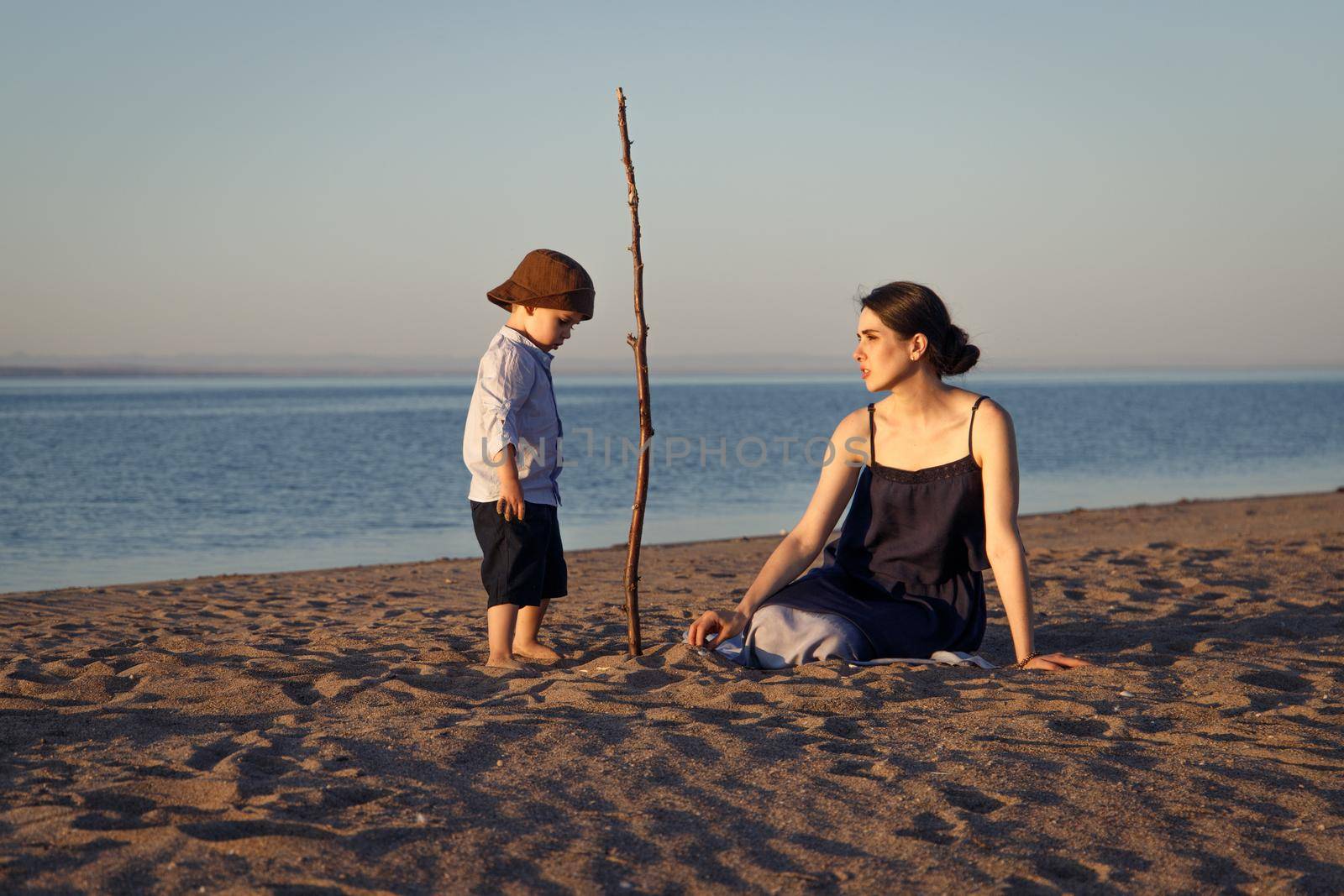 Young mother with little son 3 years old spends time on the beach playing different games.