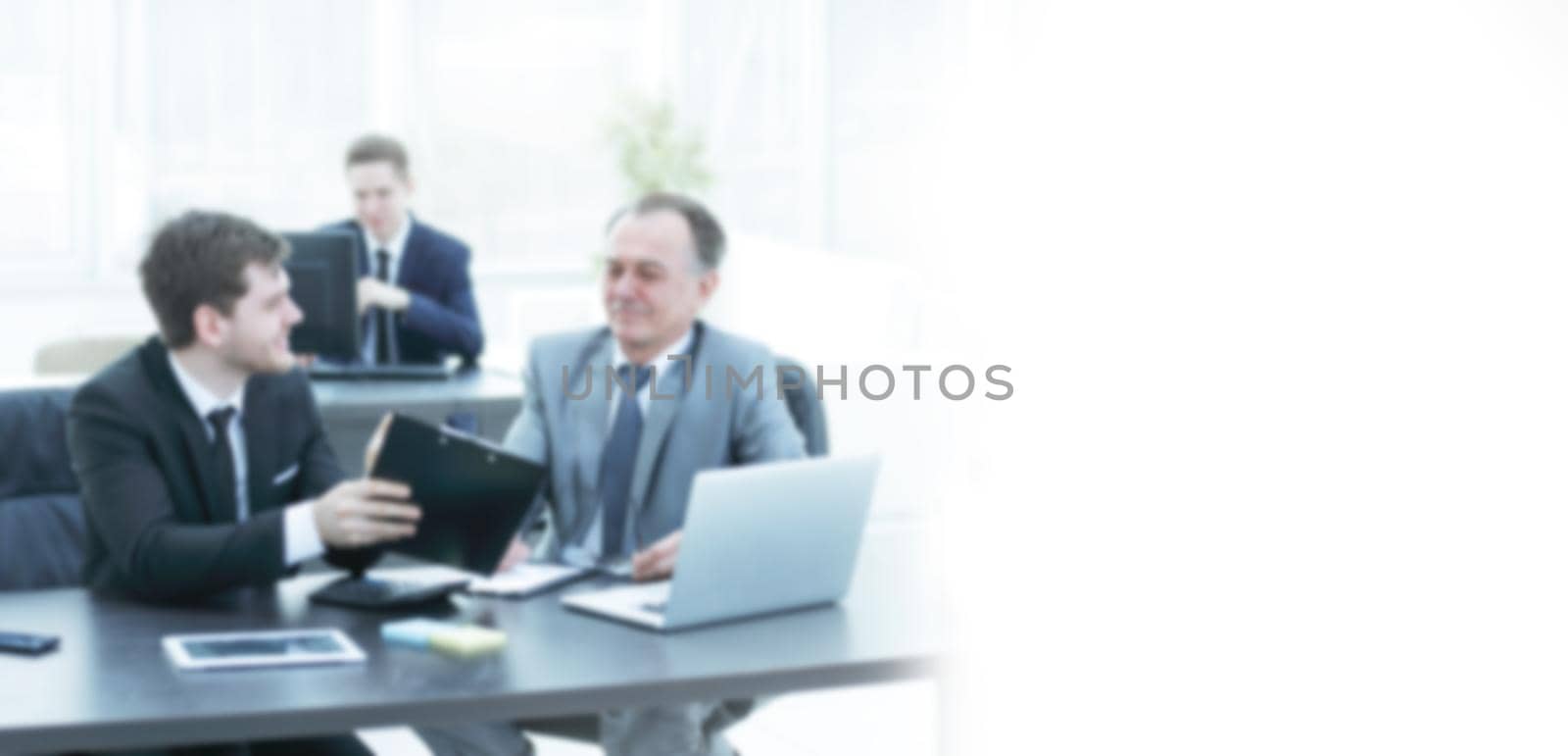 boss and employee discussing the document sitting at the Desk in the office.photo with copy space in the blur