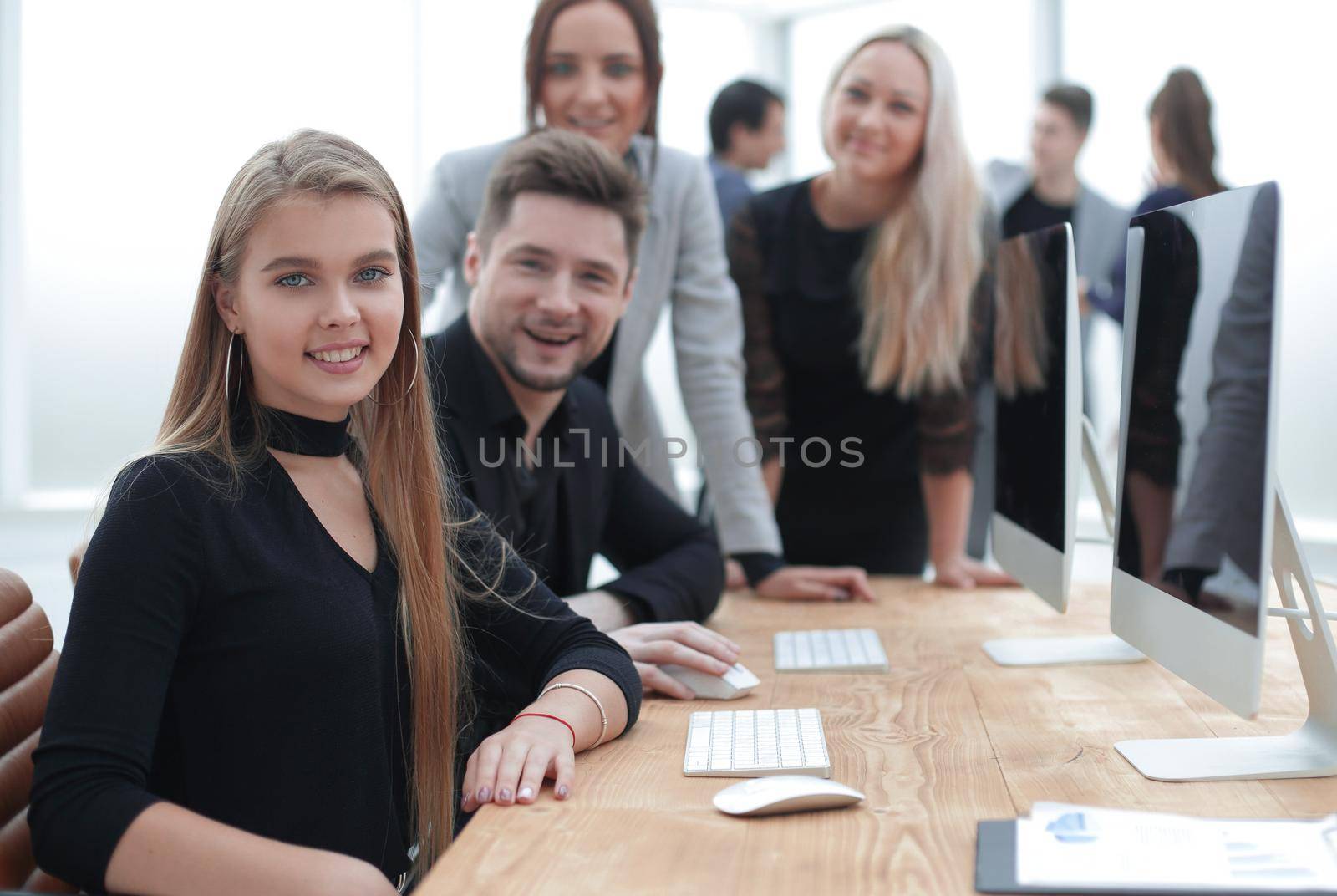 close up. young woman and a group of employees discussing online data.
