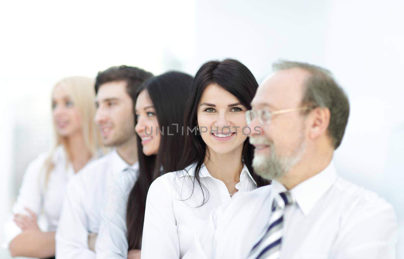 Close-up portrait of executive business people standing in a row at office and looking at the camera. Business persons.